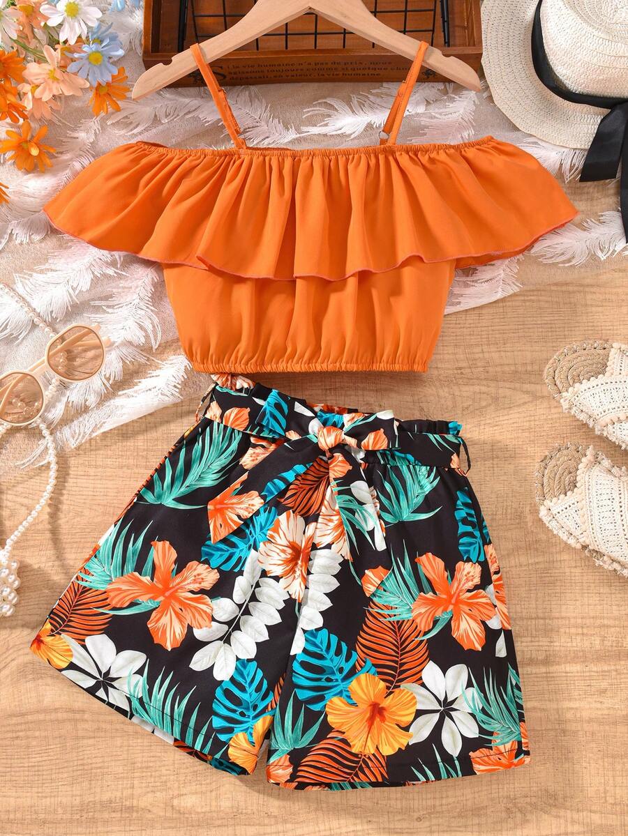 Tween girls 2-piece summer set featuring a black off-shoulder crop top with spaghetti straps and tropical leaf print ruffled paperbag waist shorts with a matching belt.
