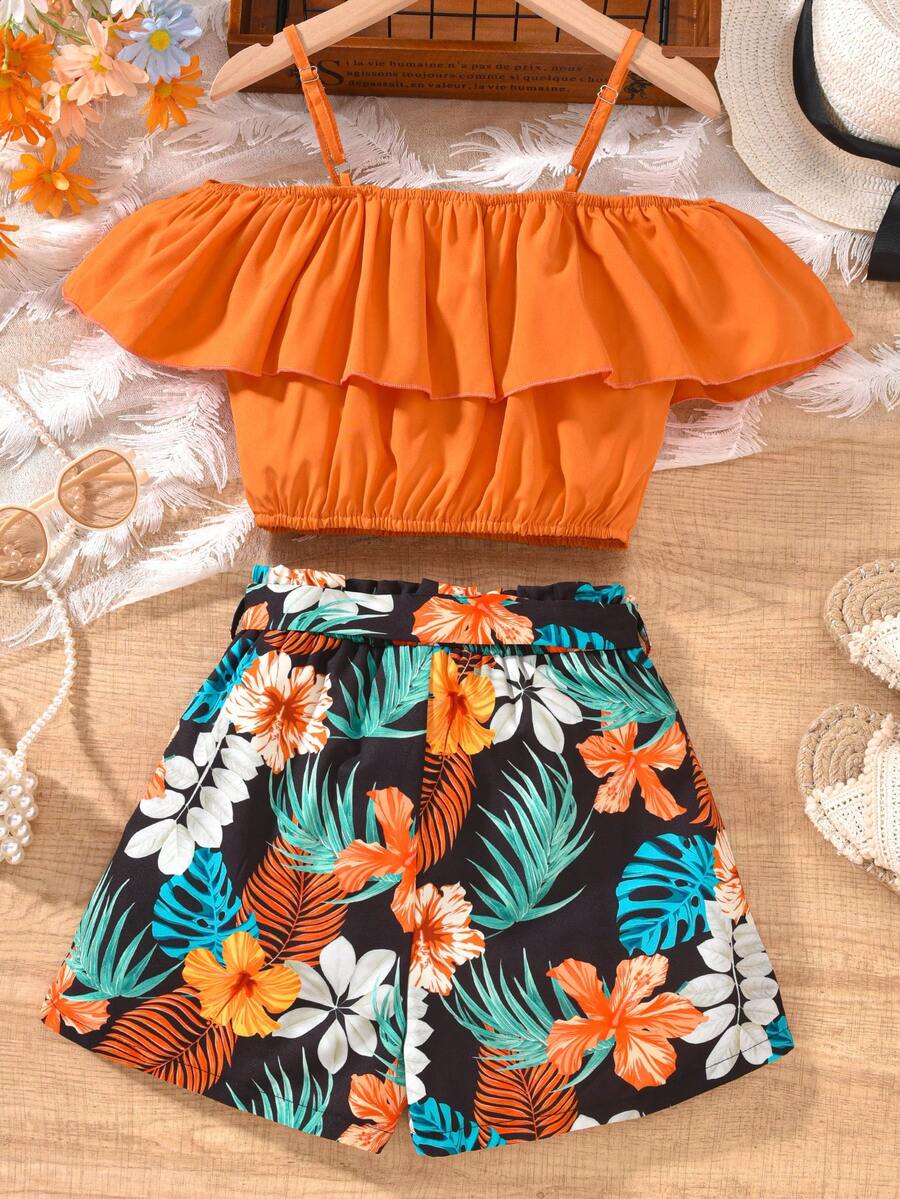 Tween girls 2-piece summer set featuring a black off-shoulder crop top with spaghetti straps and tropical leaf print ruffled paperbag waist shorts with a matching belt.