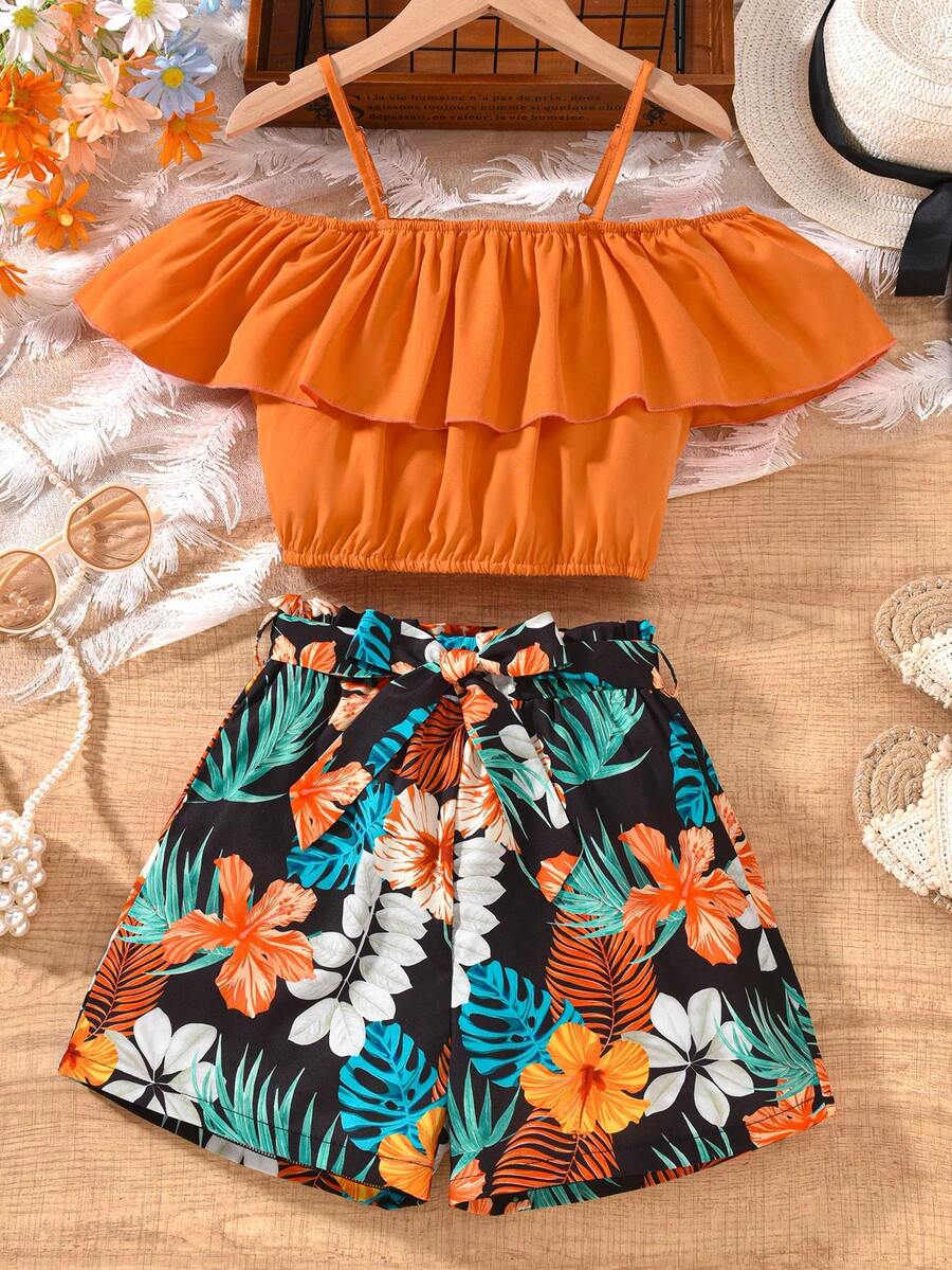 Tween girls 2-piece summer set featuring a black off-shoulder crop top with spaghetti straps and tropical leaf print ruffled paperbag waist shorts with a matching belt.