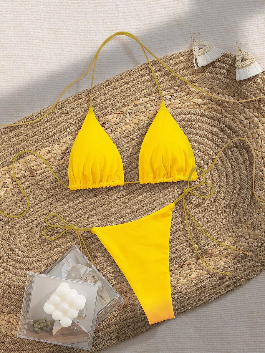 Women's 2-piece bikini set featuring a backless halter triangle top and tie-side ultra low waist bottoms.