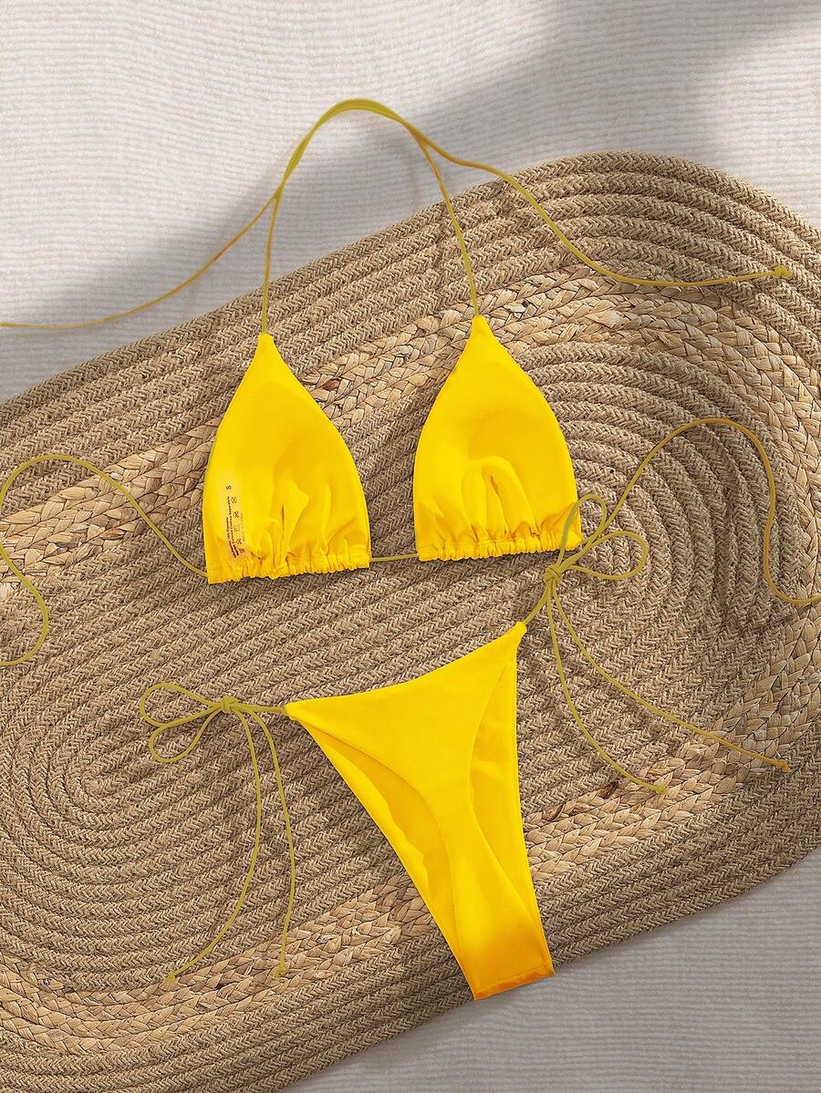 Women's 2-piece bikini set featuring a backless halter triangle top and tie-side ultra low waist bottoms.