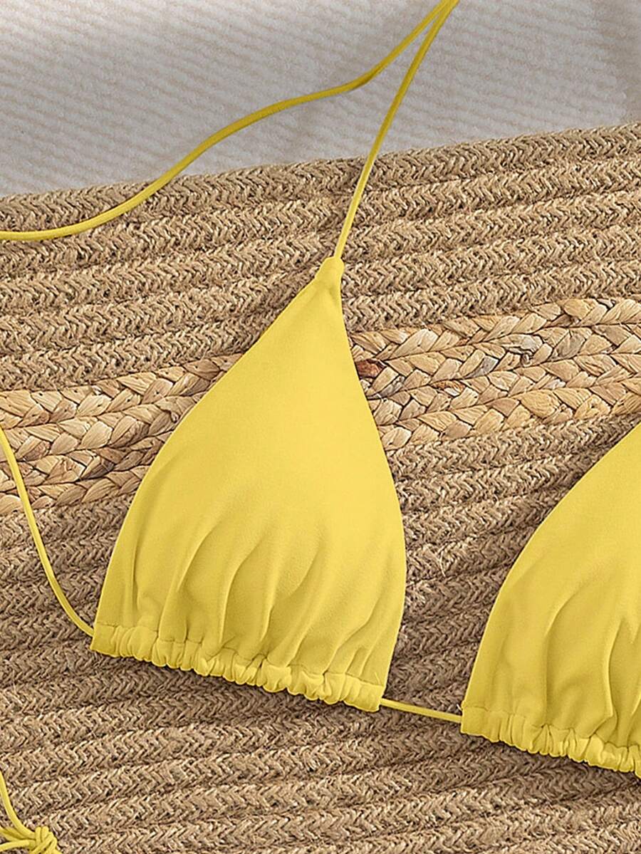 Women's 2-piece bikini set featuring a backless halter triangle top and tie-side ultra low waist bottoms.