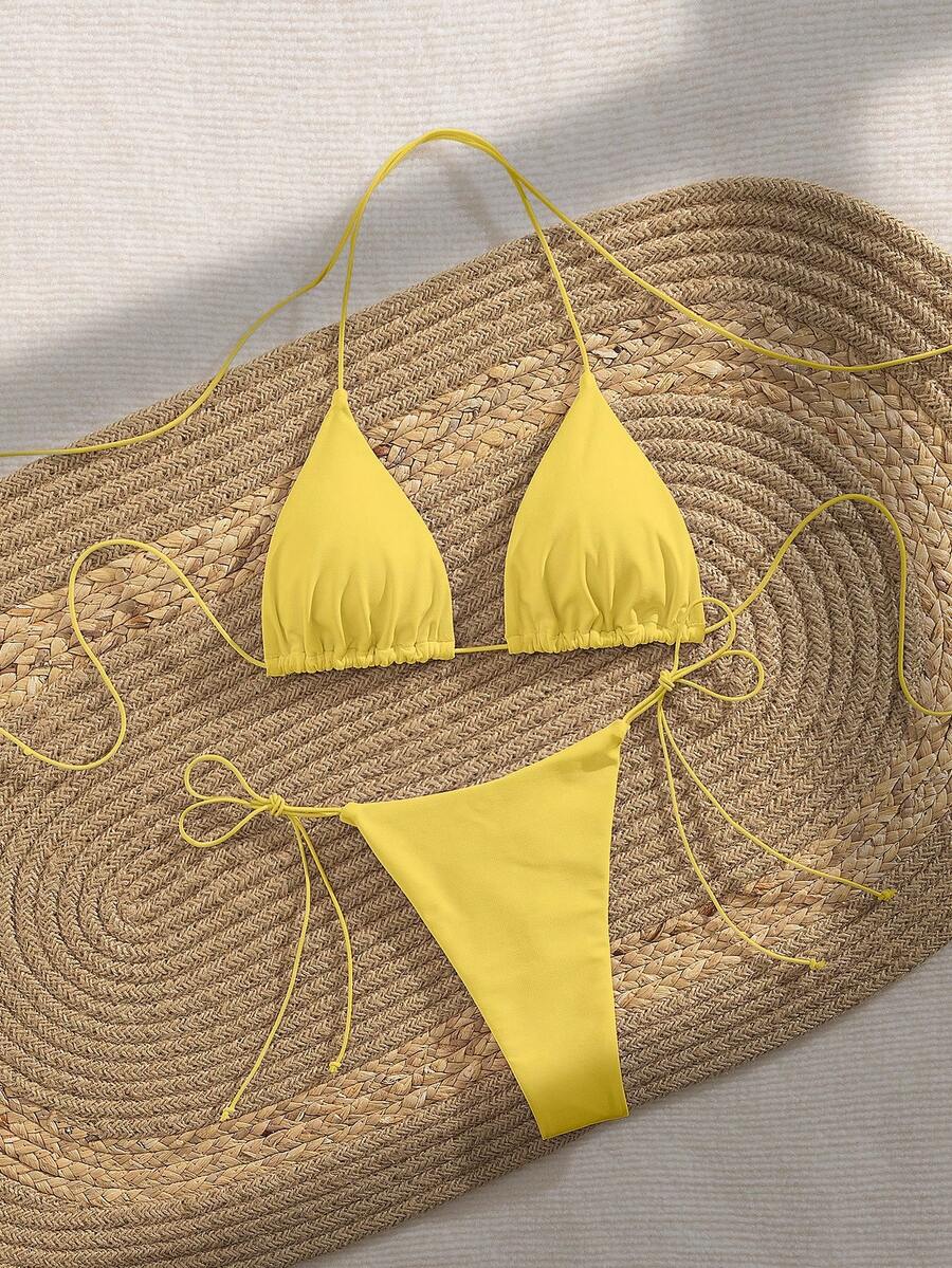 Women's 2-piece bikini set featuring a backless halter triangle top and tie-side ultra low waist bottoms.