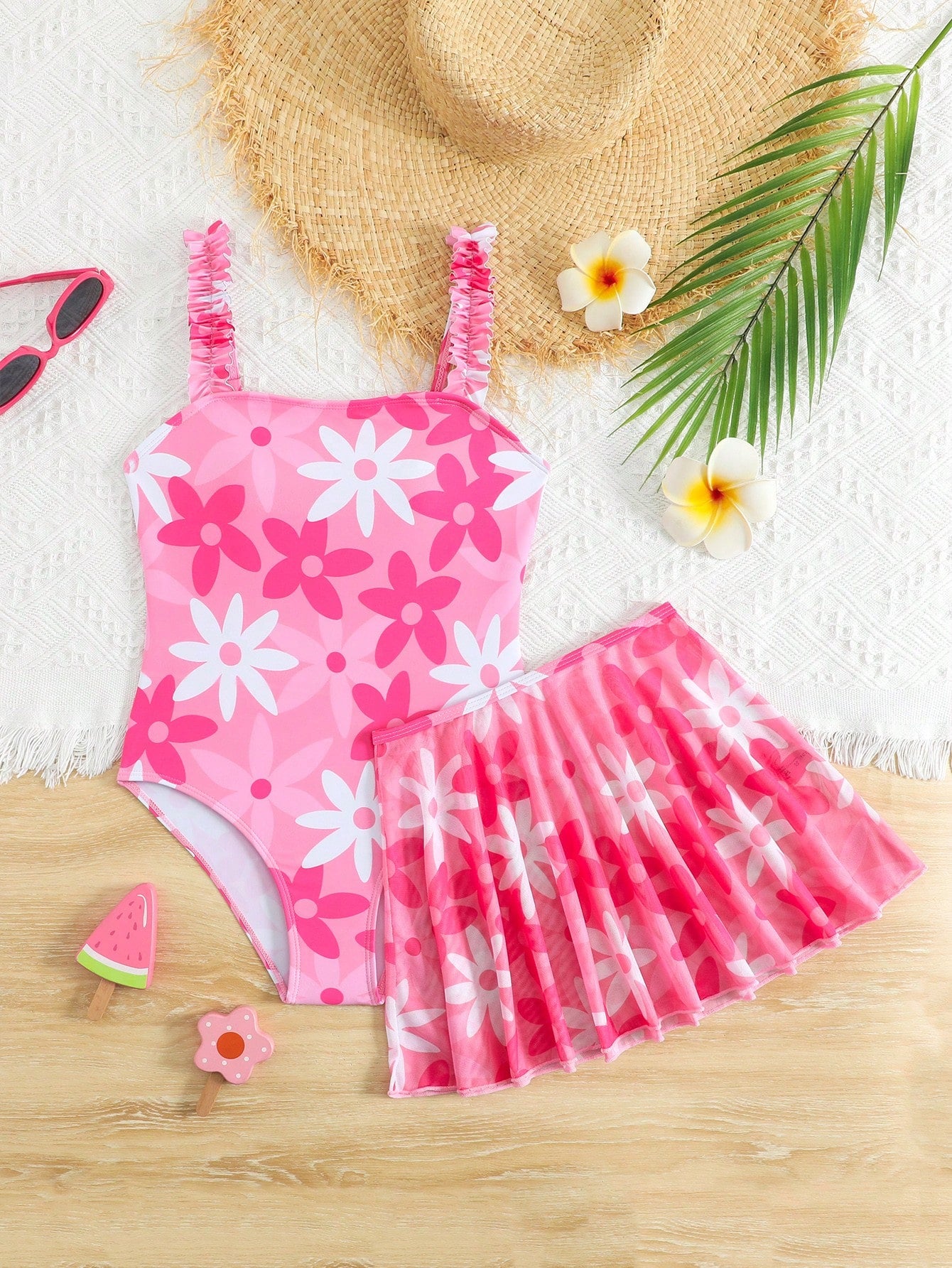 Blue tween girls one-piece swimsuit with tropical plant print, spaghetti straps, ruffle detail, and skirt-style mid-waist bottom for beach and pool wear.
