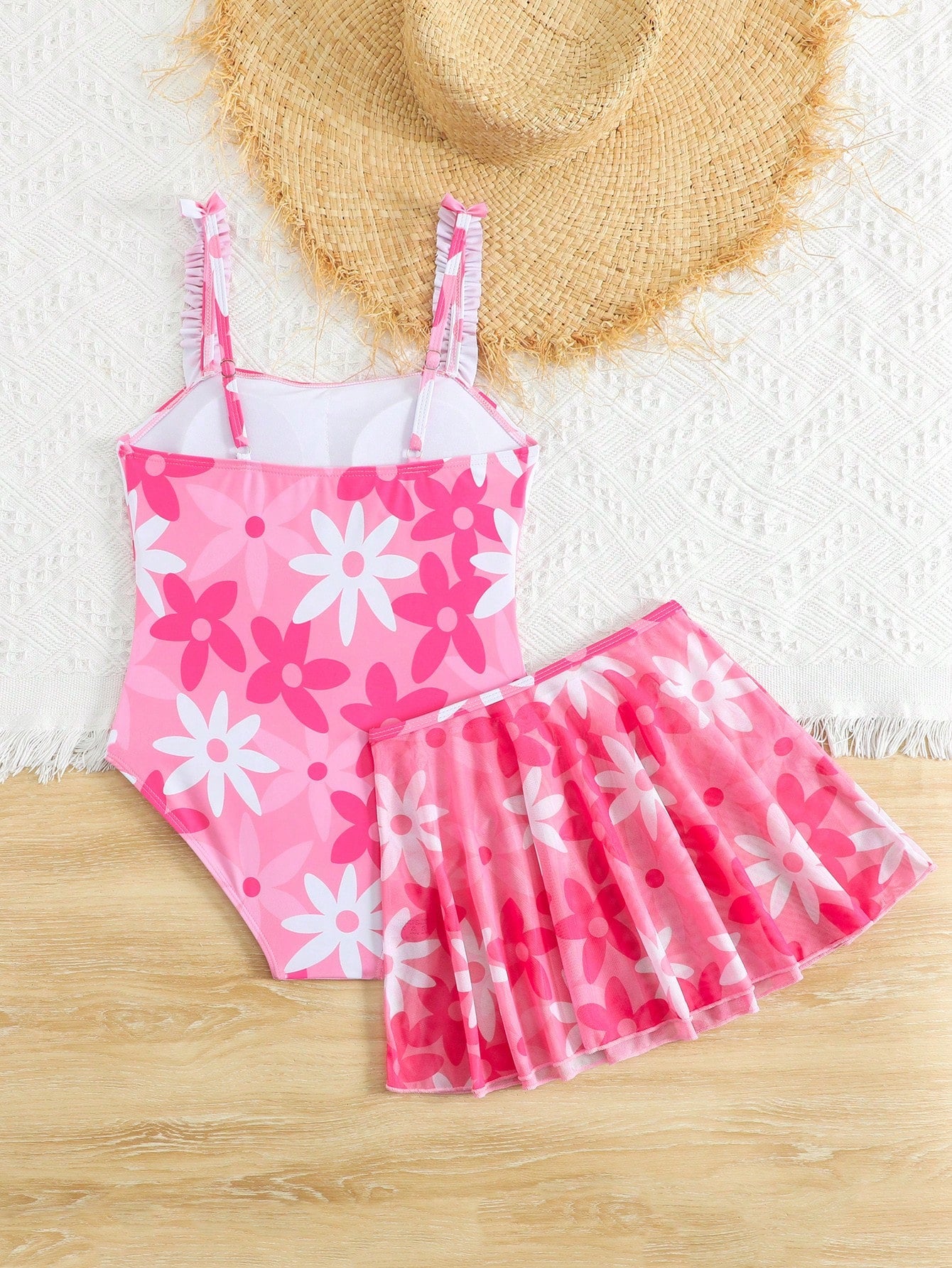 Blue tween girls one-piece swimsuit with tropical plant print, spaghetti straps, ruffle detail, and skirt-style mid-waist bottom for beach and pool wear.
