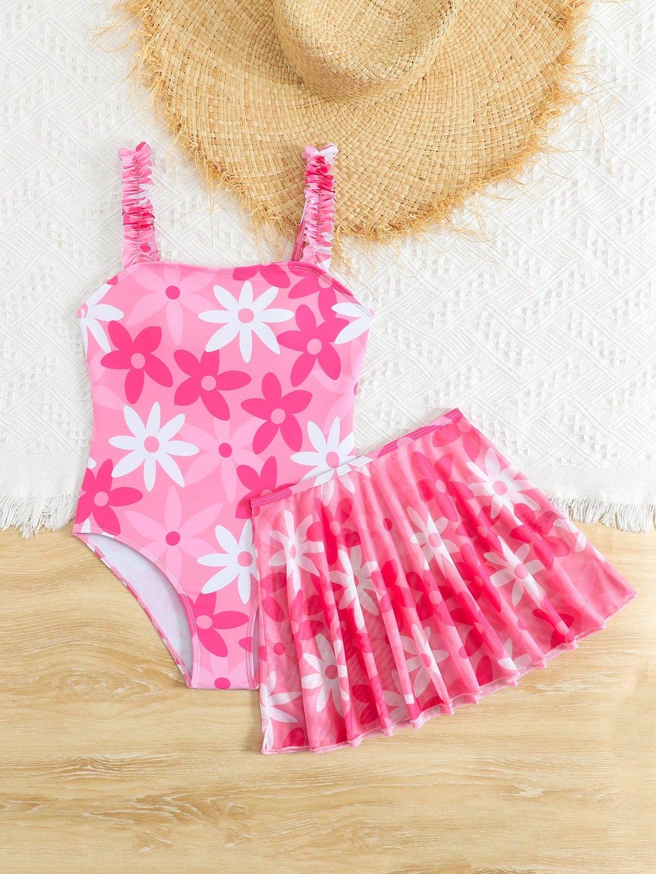 Blue tween girls one-piece swimsuit with tropical plant print, spaghetti straps, ruffle detail, and skirt-style mid-waist bottom for beach and pool wear.