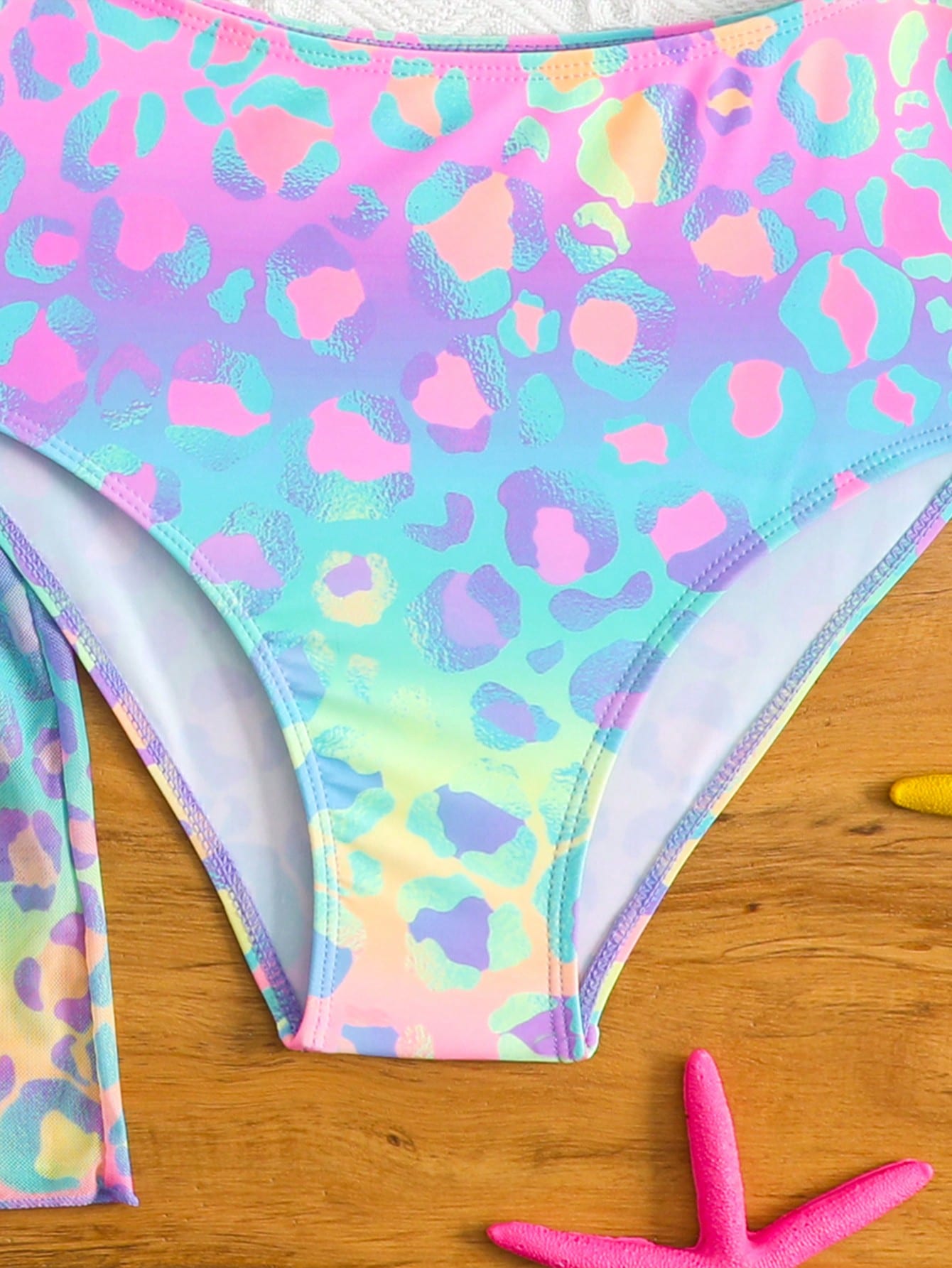 Tween girls multicolor 2-piece swimsuit set with scoop neck, cut-out details, patterned design, shorts-style bottoms, and sheer UV protection cover-up for beach and pool vacations.