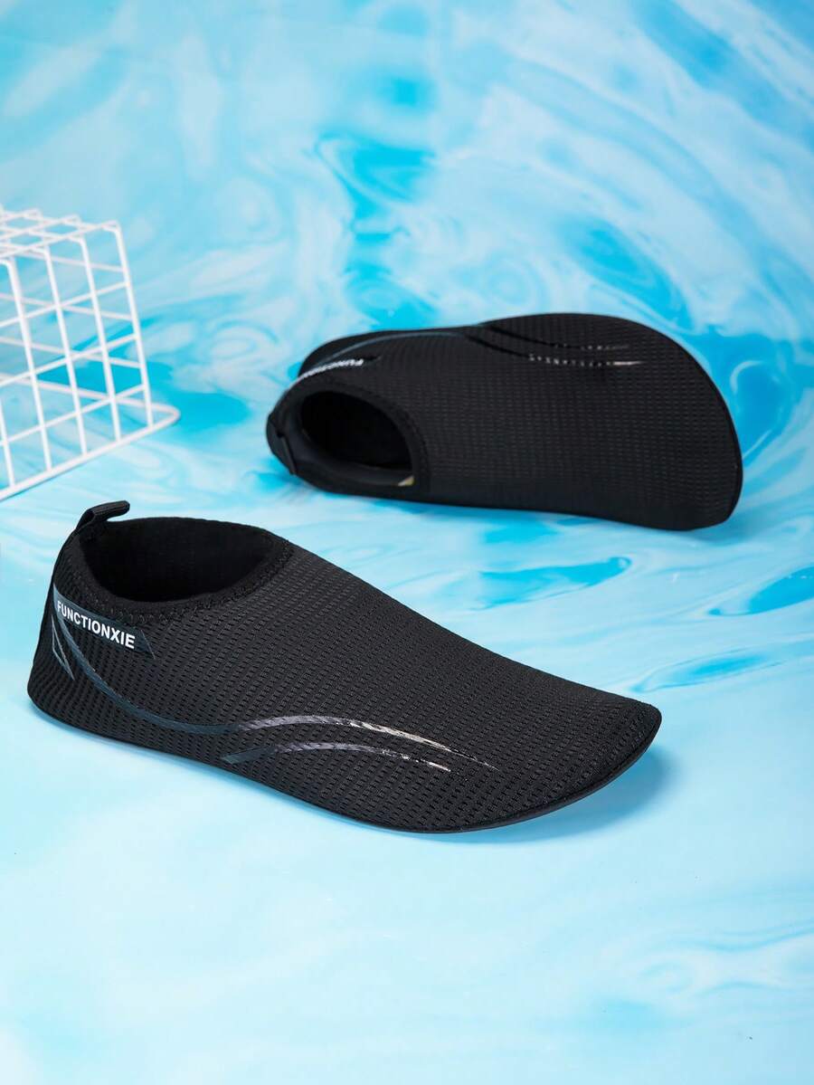 Kids black slip-on water shoes featuring a breathable mesh upper and durable rubber outsole for boys and girls.