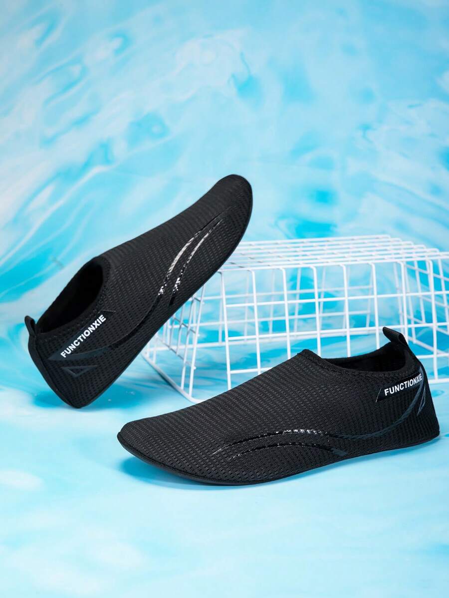 Kids black slip-on water shoes featuring a breathable mesh upper and durable rubber outsole for boys and girls.