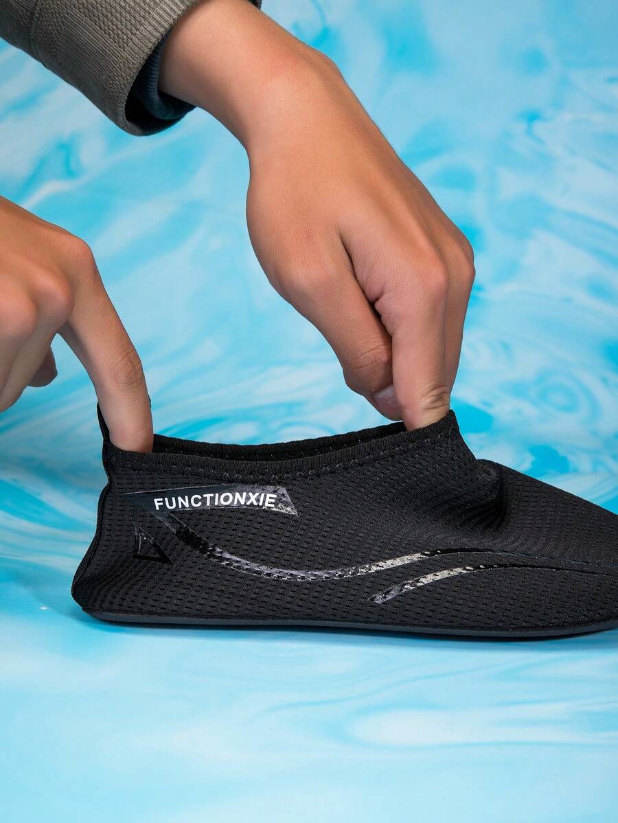 Kids black slip-on water shoes featuring a breathable mesh upper and durable rubber outsole for boys and girls.