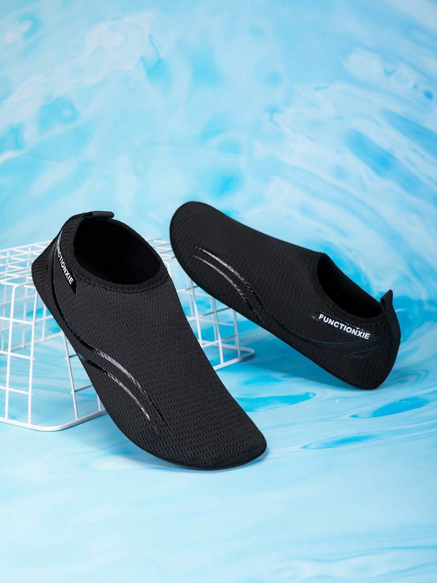 Kids black slip-on water shoes featuring a breathable mesh upper and durable rubber outsole for boys and girls.