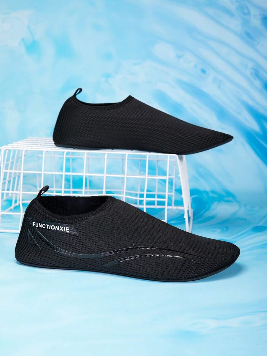 Kids black slip-on water shoes featuring a breathable mesh upper and durable rubber outsole for boys and girls.