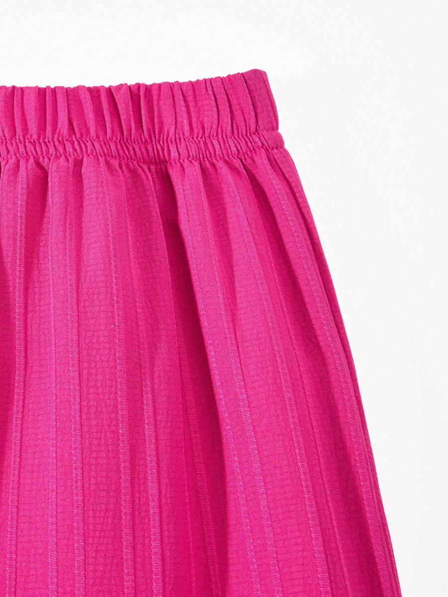 Tween girl wearing an apricot 2-piece outfit set featuring a shirred spaghetti strap short cami top and matching wide-leg long pants.