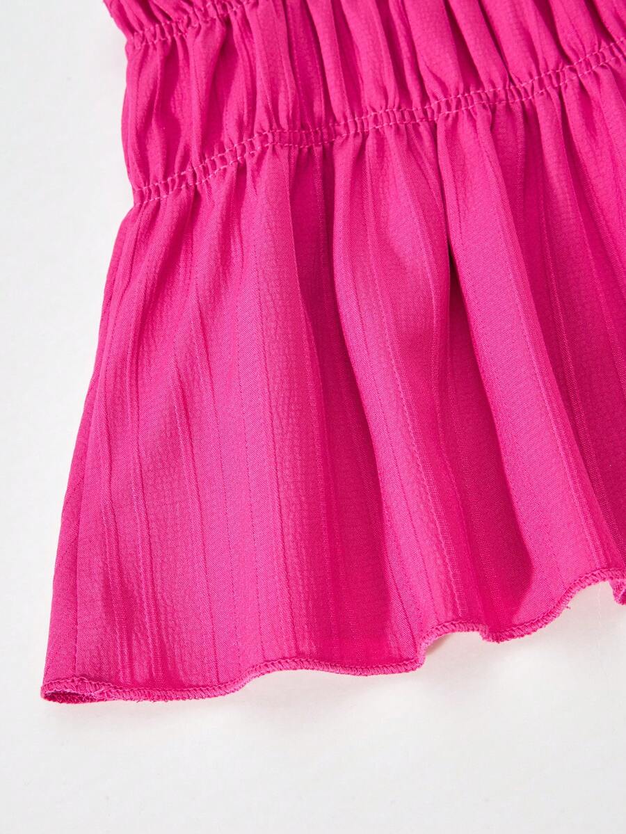 Tween girl wearing an apricot 2-piece outfit set featuring a shirred spaghetti strap short cami top and matching wide-leg long pants.