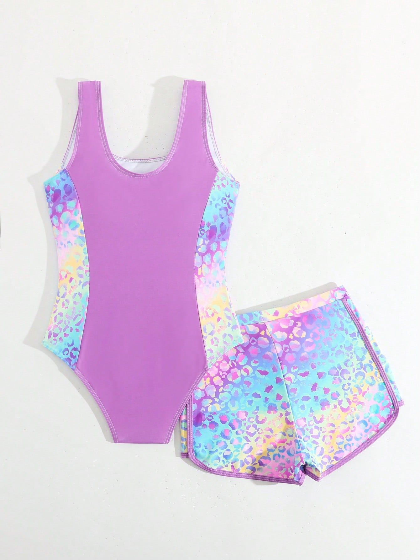 Tween girls 2-piece swimsuit set with a printed one-piece featuring ruffle trim, scoop neckline, cut-out detail, and matching shorts bottom.