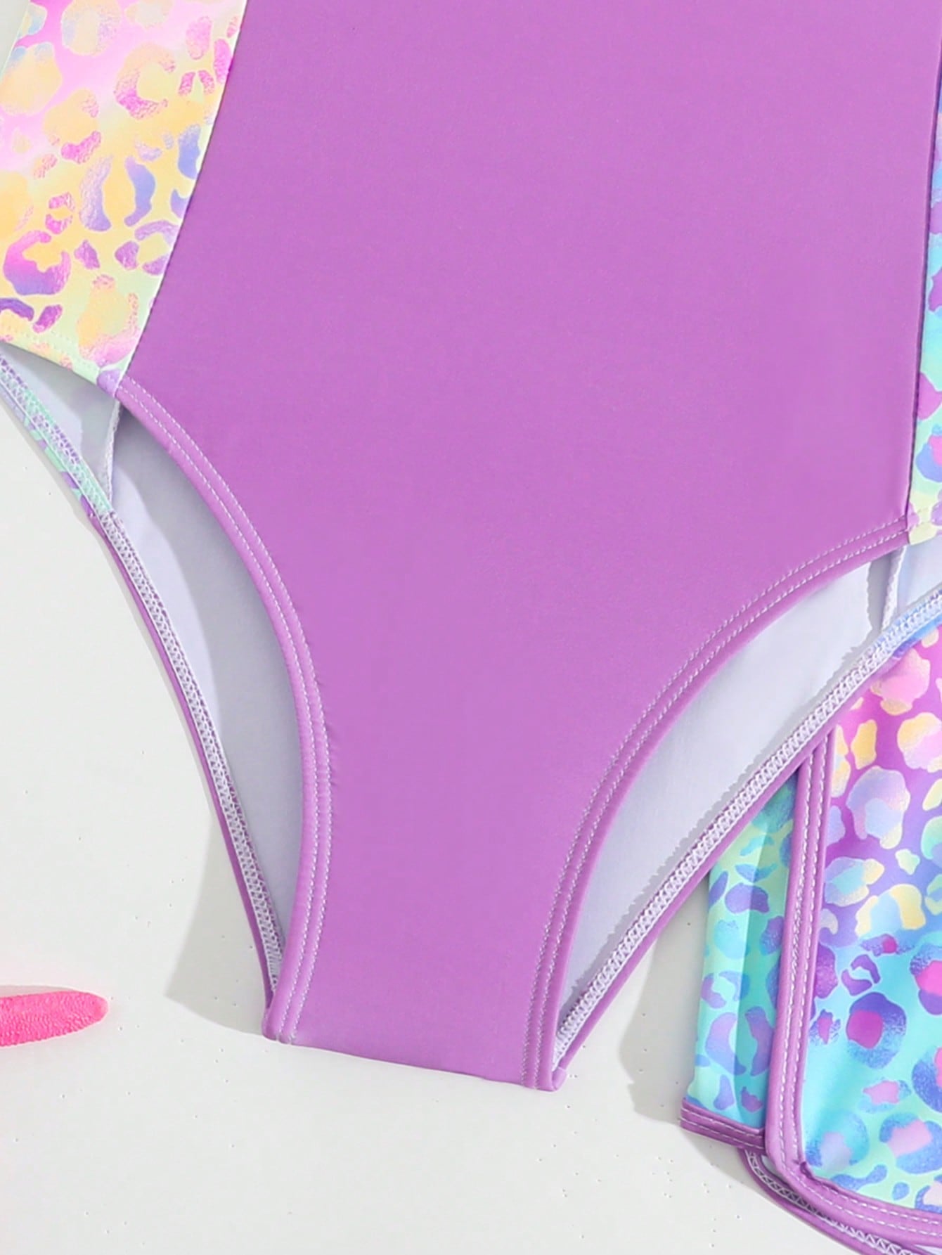 Tween girls 2-piece swimsuit set with a printed one-piece featuring ruffle trim, scoop neckline, cut-out detail, and matching shorts bottom.