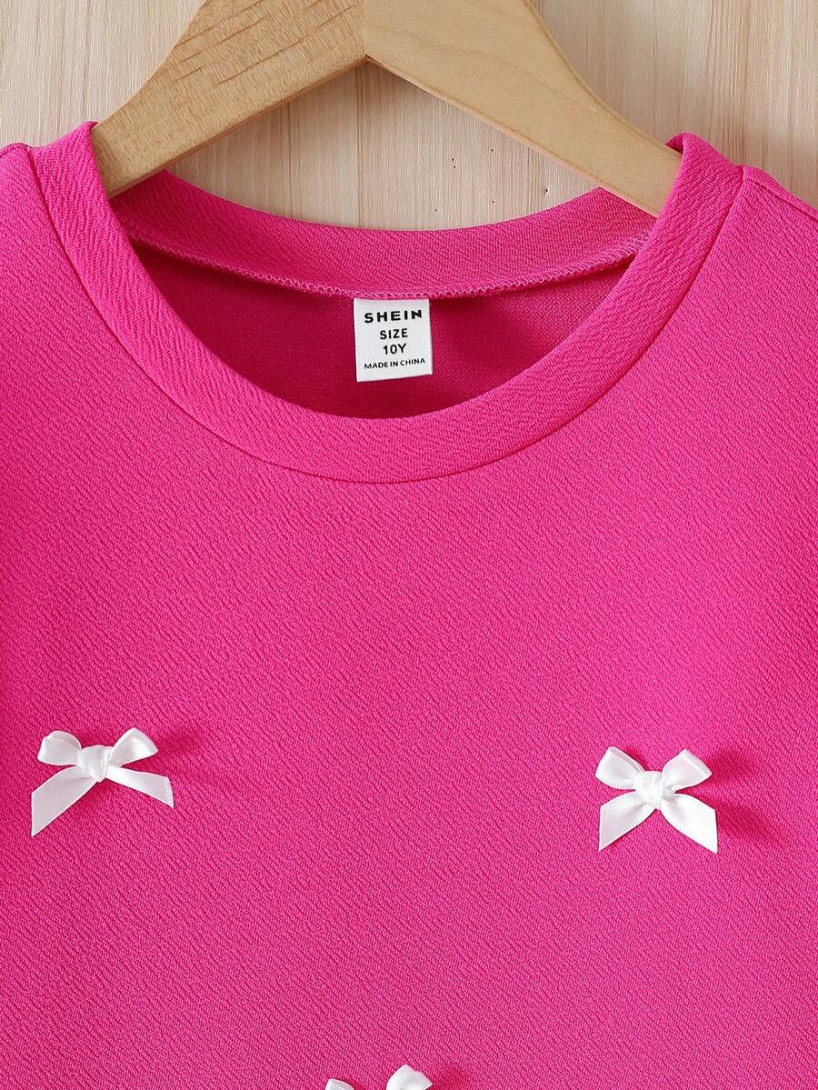 Tween girls apricot short-sleeve pleated smock dress with 3D bow decor and round neckline.