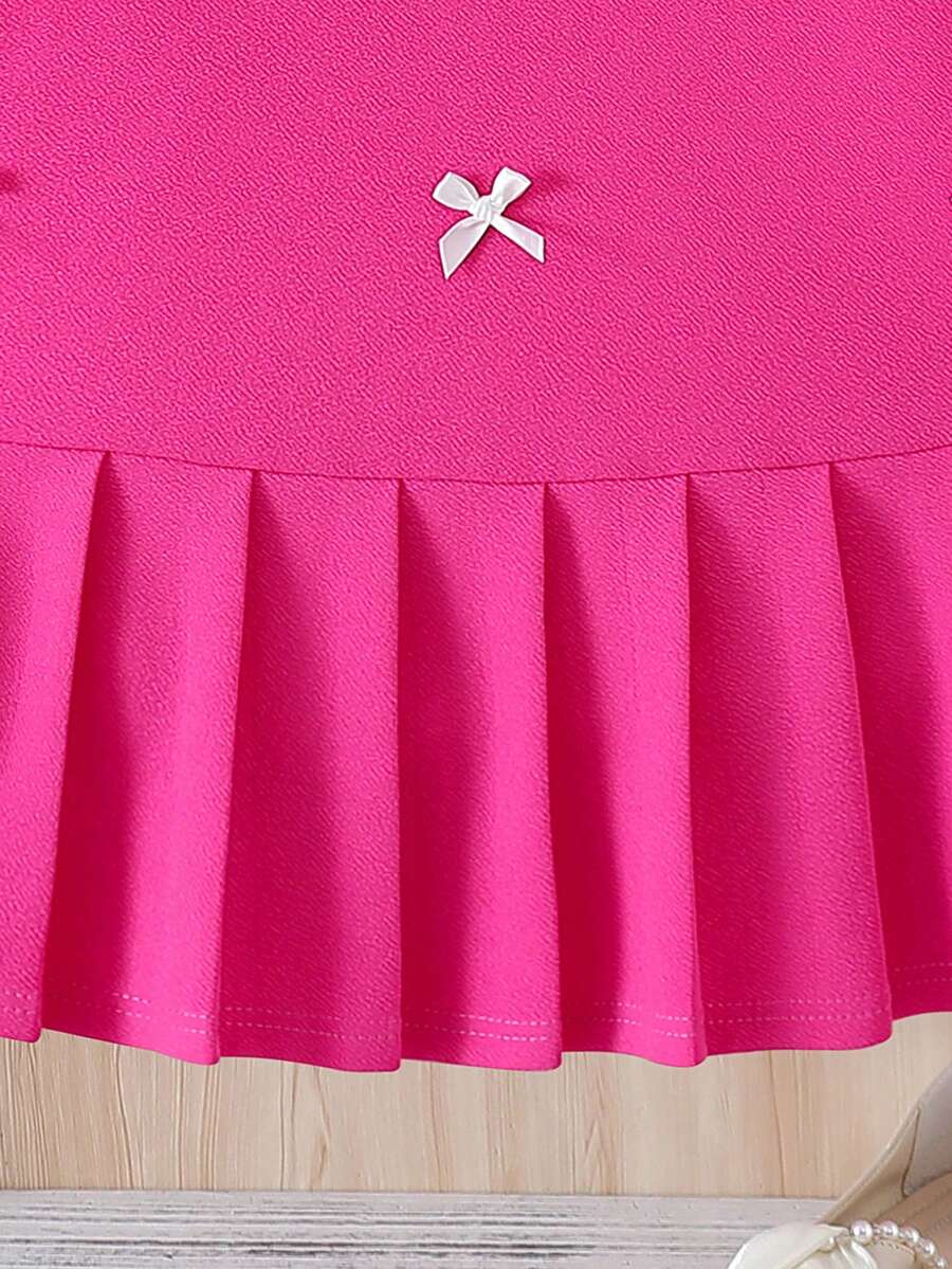 Tween girls apricot short-sleeve pleated smock dress with 3D bow decor and round neckline.