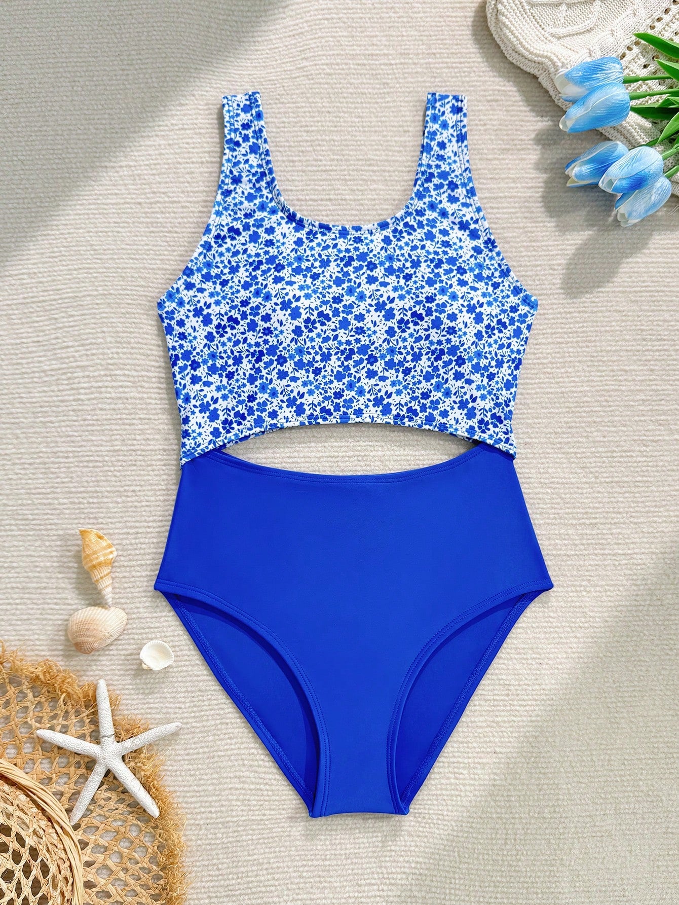 Tween girls blue and white floral one-piece swimsuit with scoop neck, cut-out detail, lined body, and high-stretch fabric for beach and vacation wear.