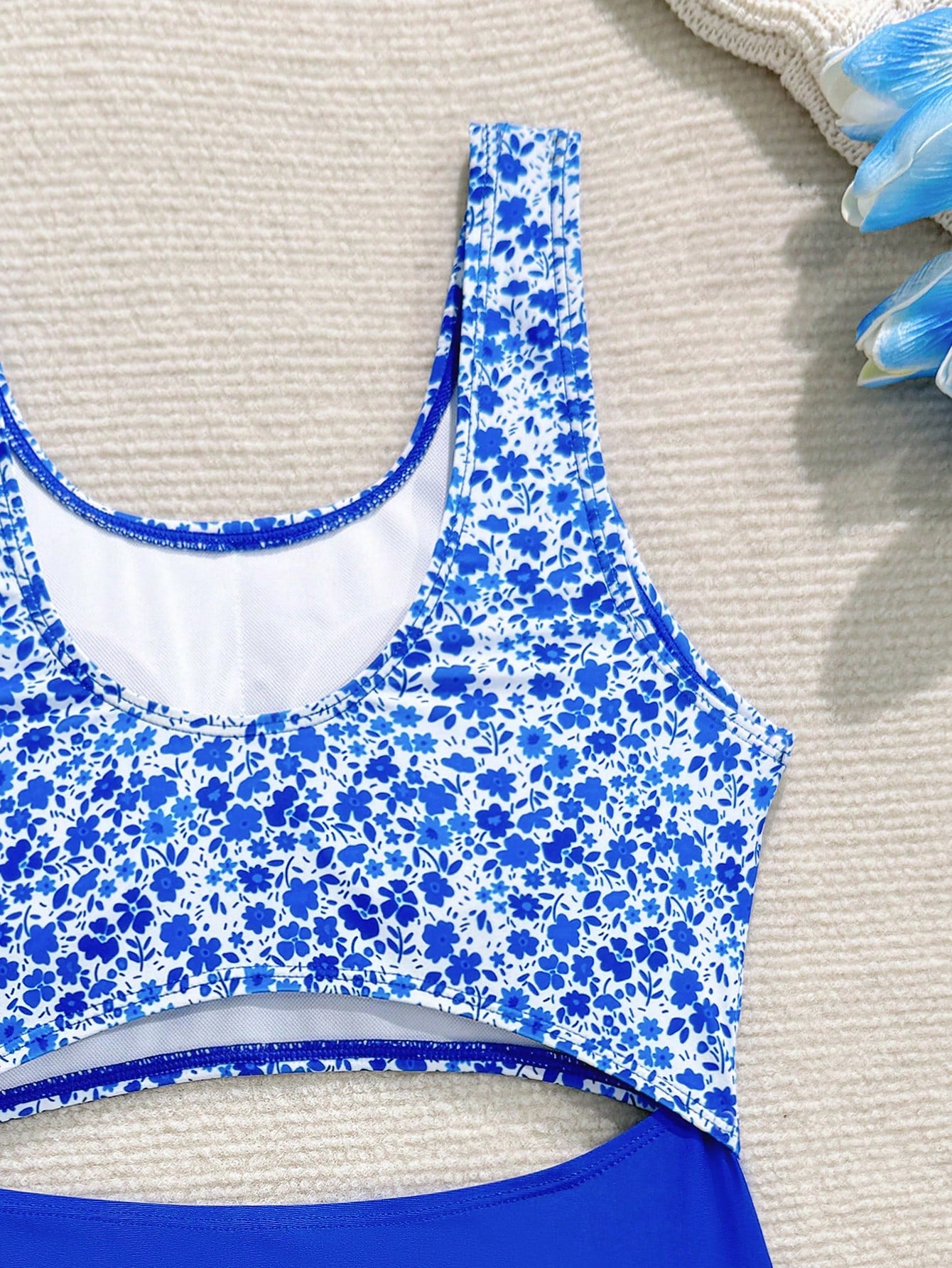 Tween girls blue and white floral one-piece swimsuit with scoop neck, cut-out detail, lined body, and high-stretch fabric for beach and vacation wear.