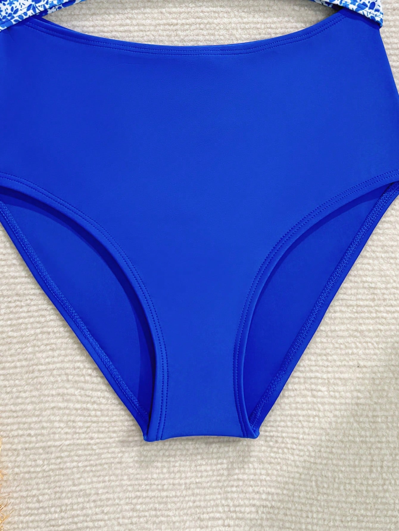 Tween girls blue and white floral one-piece swimsuit with scoop neck, cut-out detail, lined body, and high-stretch fabric for beach and vacation wear.