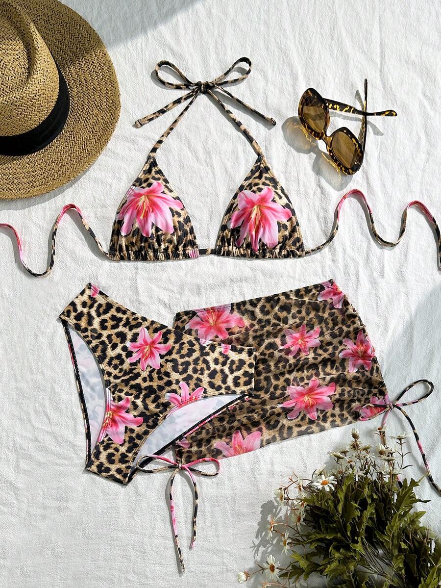 Women's black 3-piece bikini set featuring a halter triangle top with removable padding, high-waisted bottoms, and a knee-length mesh skirt with tie details.