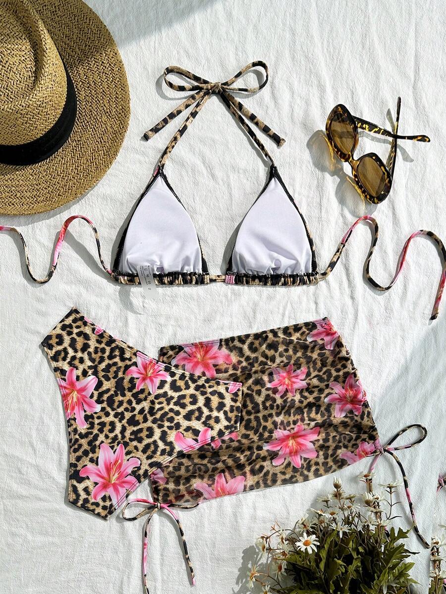 Women's black 3-piece bikini set featuring a halter triangle top with removable padding, high-waisted bottoms, and a knee-length mesh skirt with tie details.