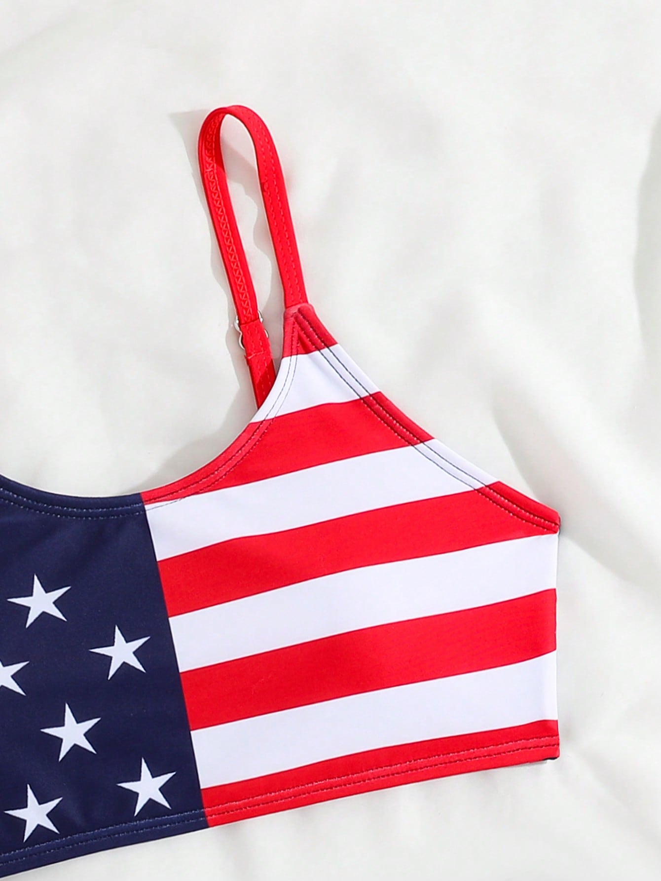Blue tween girls bikini set with American flag and geometric print, featuring a sleeveless spaghetti strap wireless bikini top and high-waist bikini bottoms, suitable for summer beach vacation.