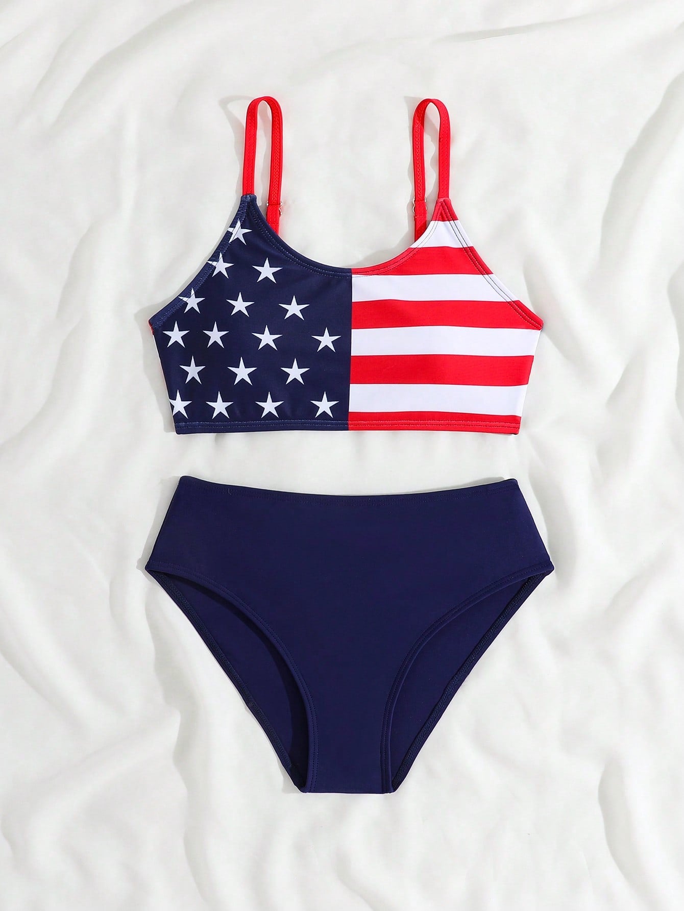 Blue tween girls bikini set with American flag and geometric print, featuring a sleeveless spaghetti strap wireless bikini top and high-waist bikini bottoms, suitable for summer beach vacation.