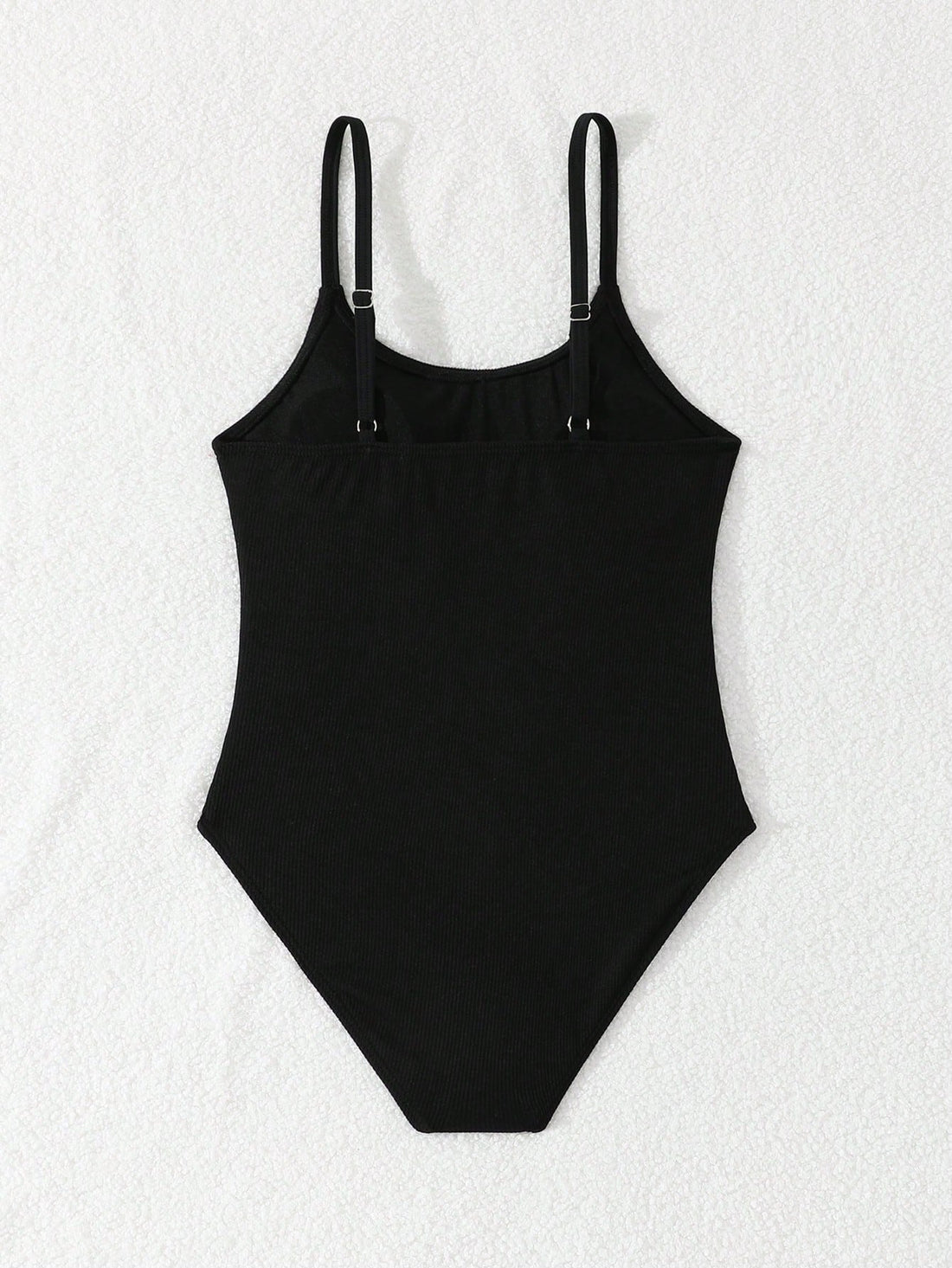 Tween girls' black rib knit one-piece swimsuit with spaghetti straps, plain textured fabric, short length, and vacation swimwear style.