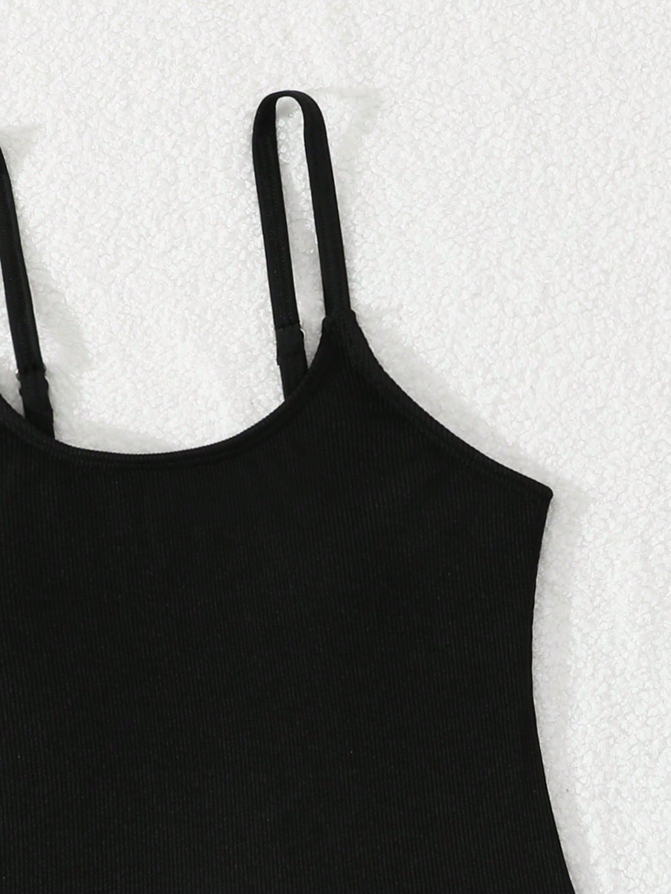 Tween girls' black rib knit one-piece swimsuit with spaghetti straps, plain textured fabric, short length, and vacation swimwear style.