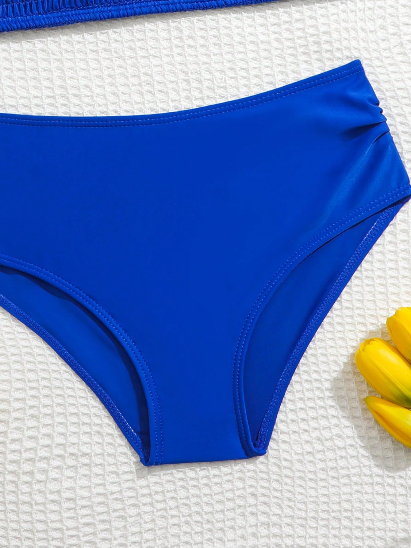 Tween girls tankini swimwear set with a solid color cap sleeve top featuring strap neckline and ruffle detail, paired with triangle-style briefs in a high-waist to mid-waist fit; two-piece vacation swim set.