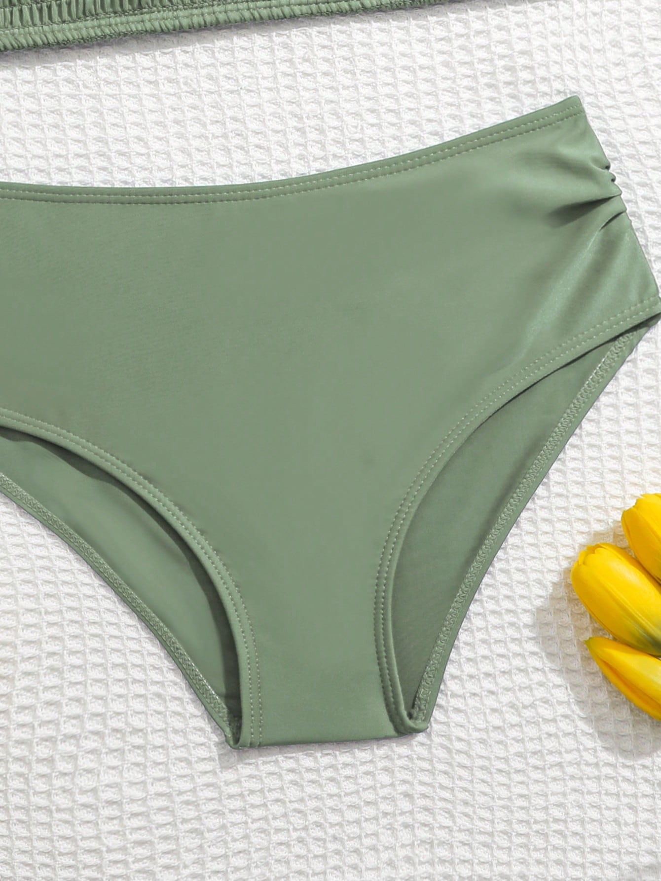 Tween girls tankini swimwear set with a solid color cap sleeve top featuring strap neckline and ruffle detail, paired with triangle-style briefs in a high-waist to mid-waist fit; two-piece vacation swim set.