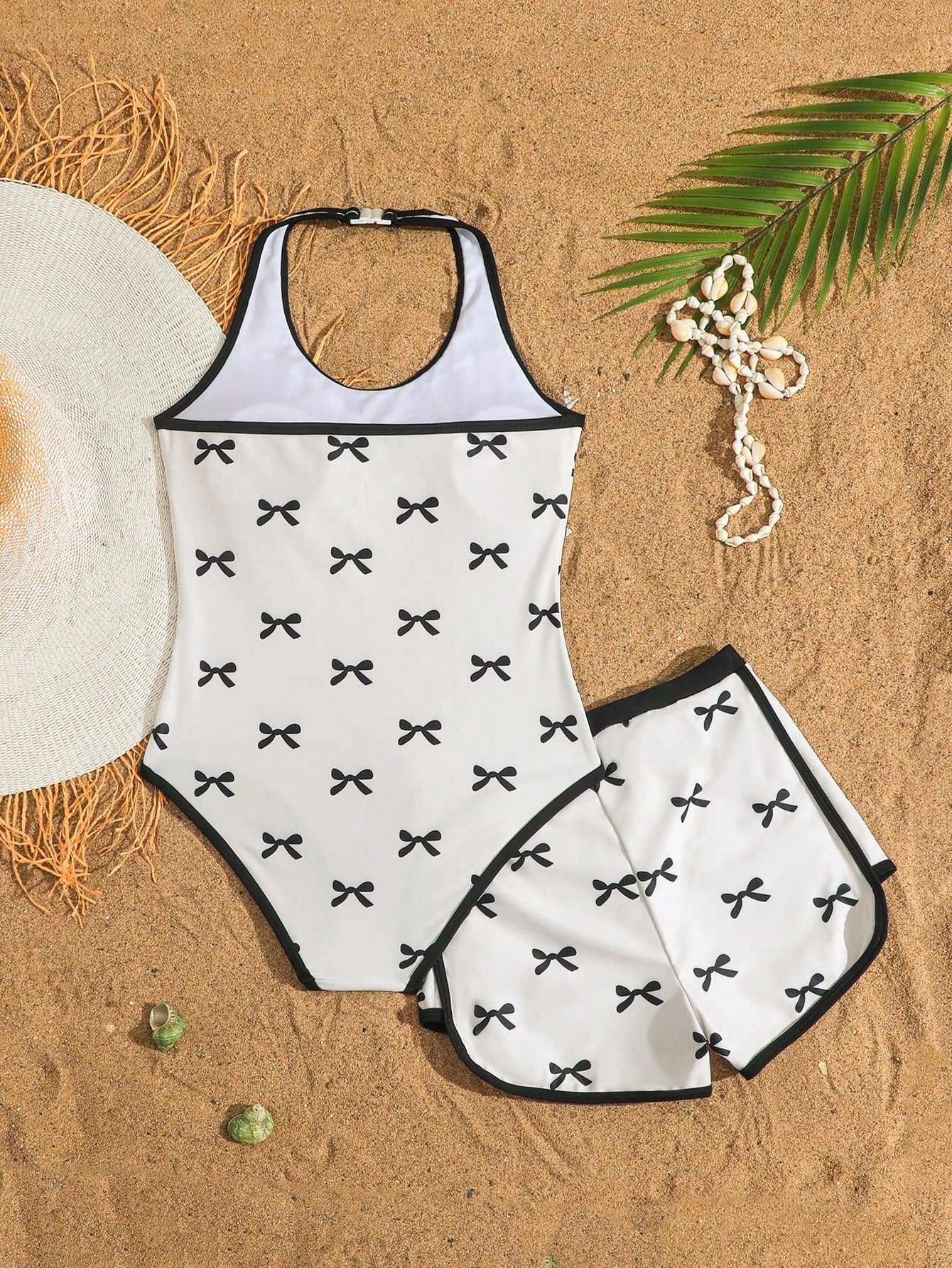 Girls 2-piece swimwear set featuring a butterfly print halter swimsuit top with contrast piping and separate mid-waist shorts; sleeveless, high-stretch, wireless design for beach and vacation wear.