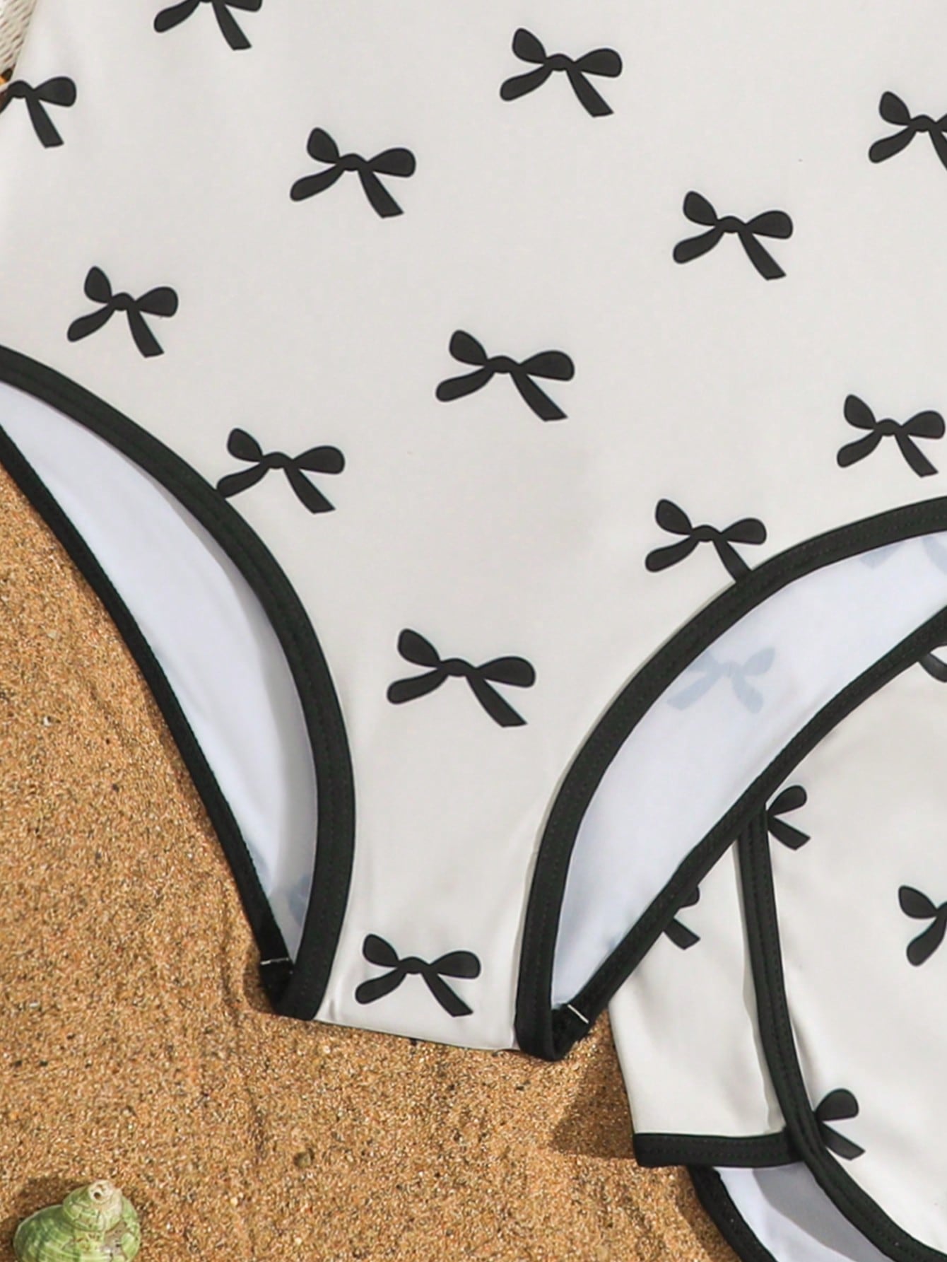 Girls 2-piece swimwear set featuring a butterfly print halter swimsuit top with contrast piping and separate mid-waist shorts; sleeveless, high-stretch, wireless design for beach and vacation wear.