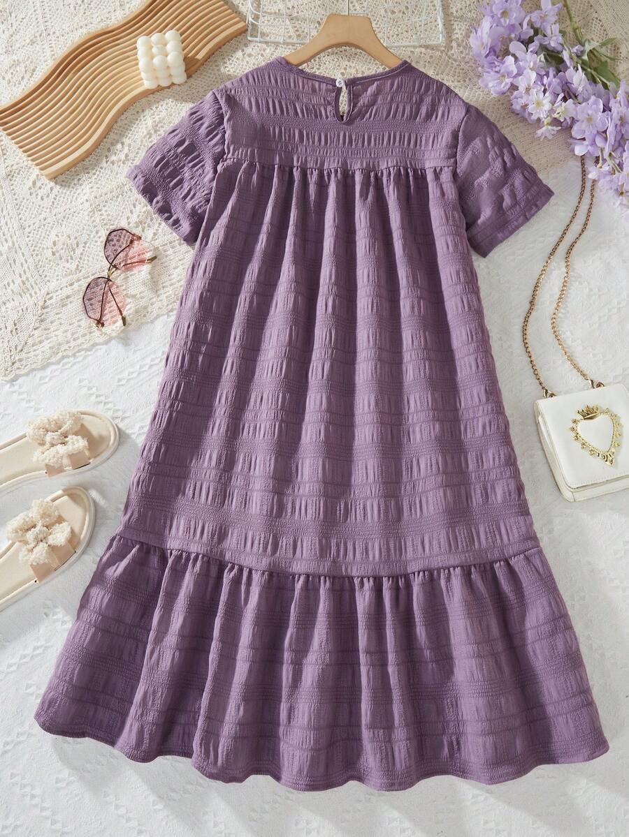 Tween girl wearing an Army Green textured short sleeve smock midi dress with round neck and ruffle flounce hem.