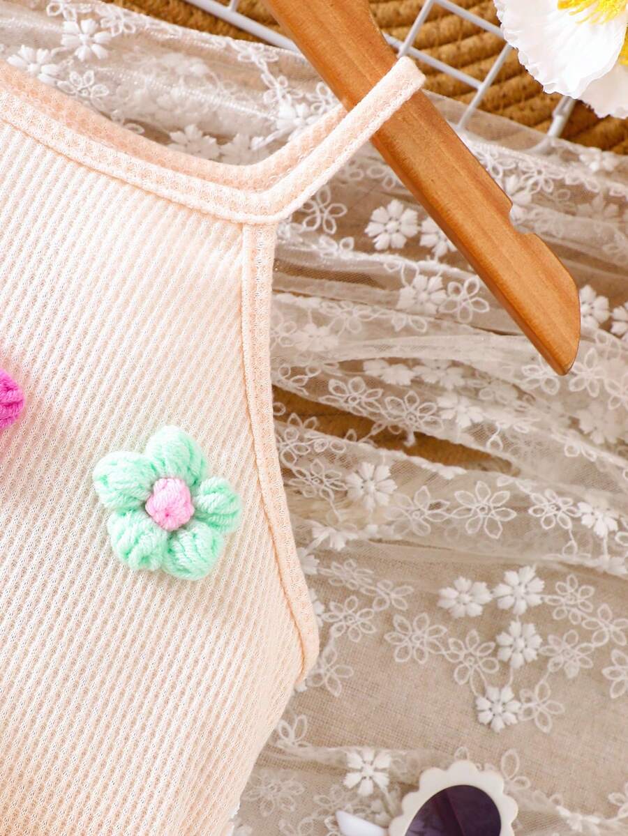 Girls' sleeveless summer midi dress with halter neckline, geometric pattern, applique and fringe details, shown with crossbody bag accessory with tassel decor