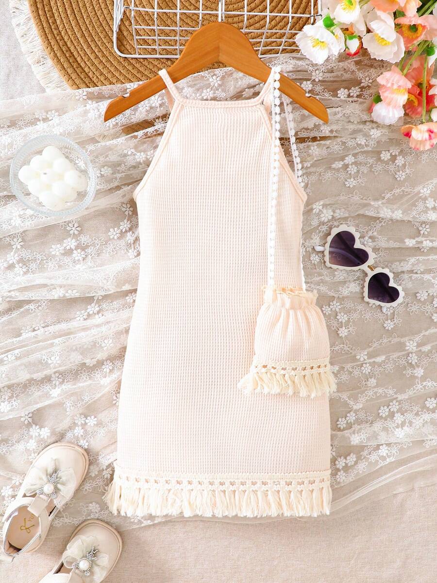 Girls' sleeveless summer midi dress with halter neckline, geometric pattern, applique and fringe details, shown with crossbody bag accessory with tassel decor