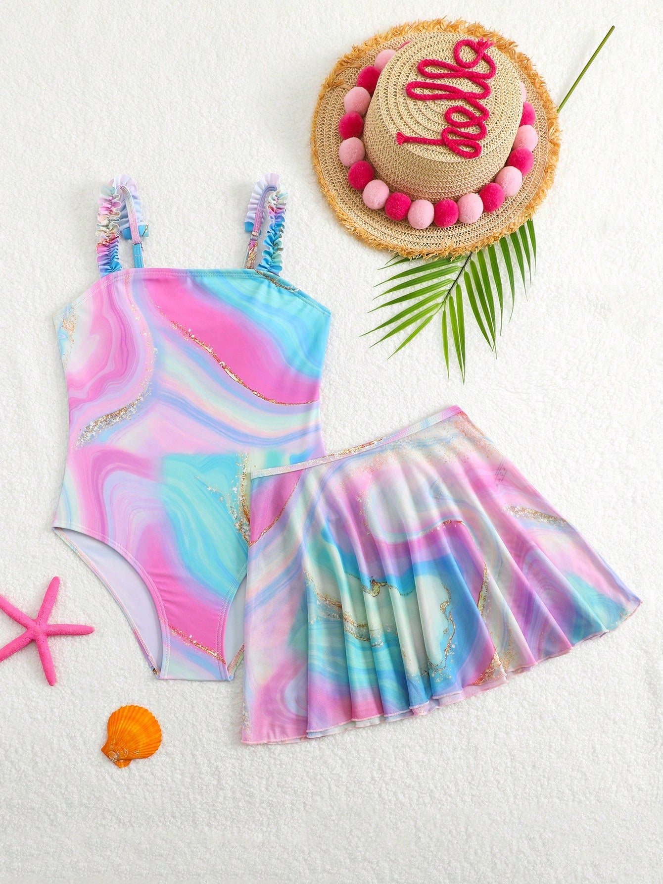 Blue tween girls one-piece swimsuit with tropical plant print, spaghetti straps, ruffle detail, and skirt-style mid-waist bottom for beach and pool wear.