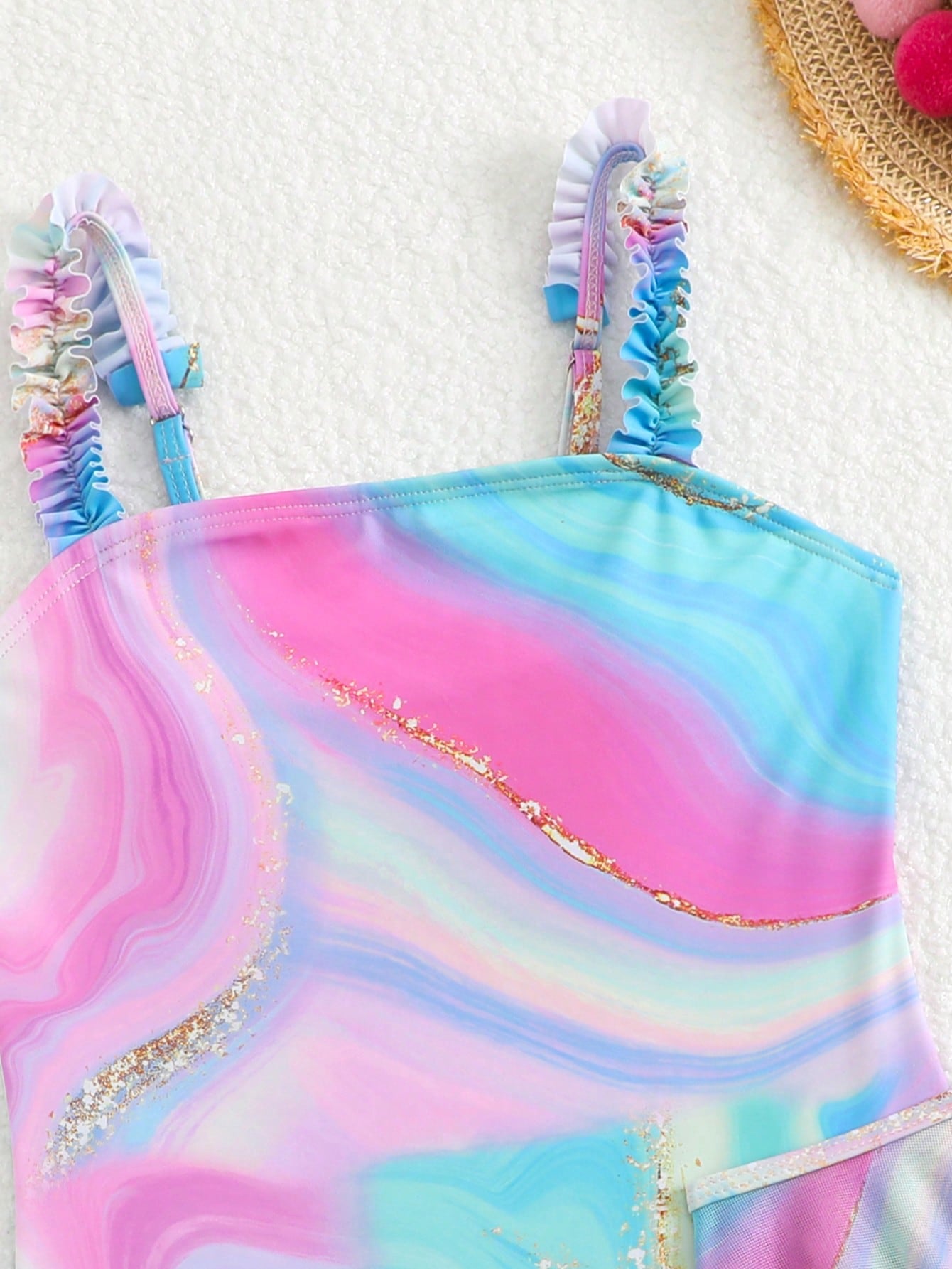 Blue tween girls one-piece swimsuit with tropical plant print, spaghetti straps, ruffle detail, and skirt-style mid-waist bottom for beach and pool wear.