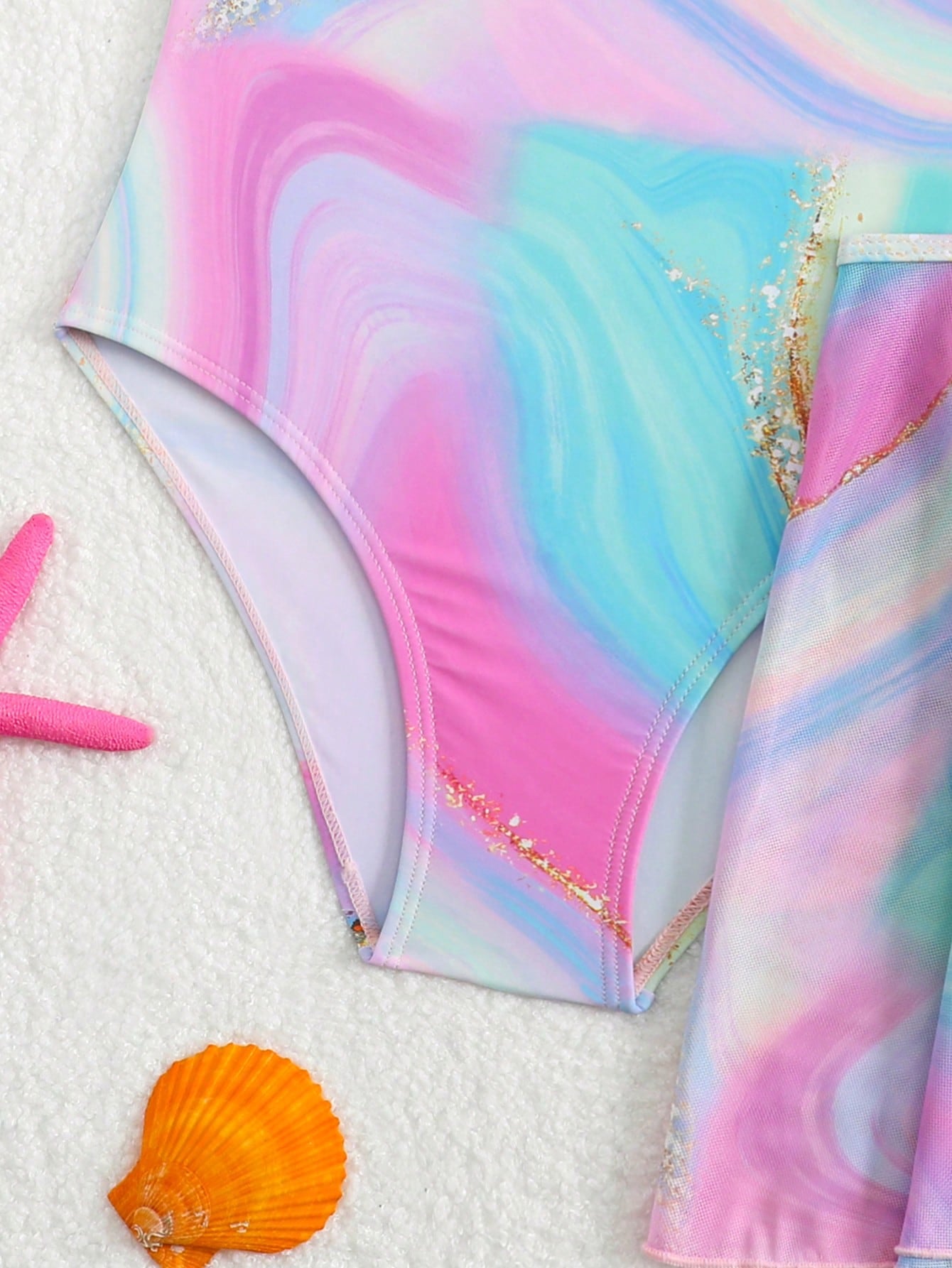 Blue tween girls one-piece swimsuit with tropical plant print, spaghetti straps, ruffle detail, and skirt-style mid-waist bottom for beach and pool wear.