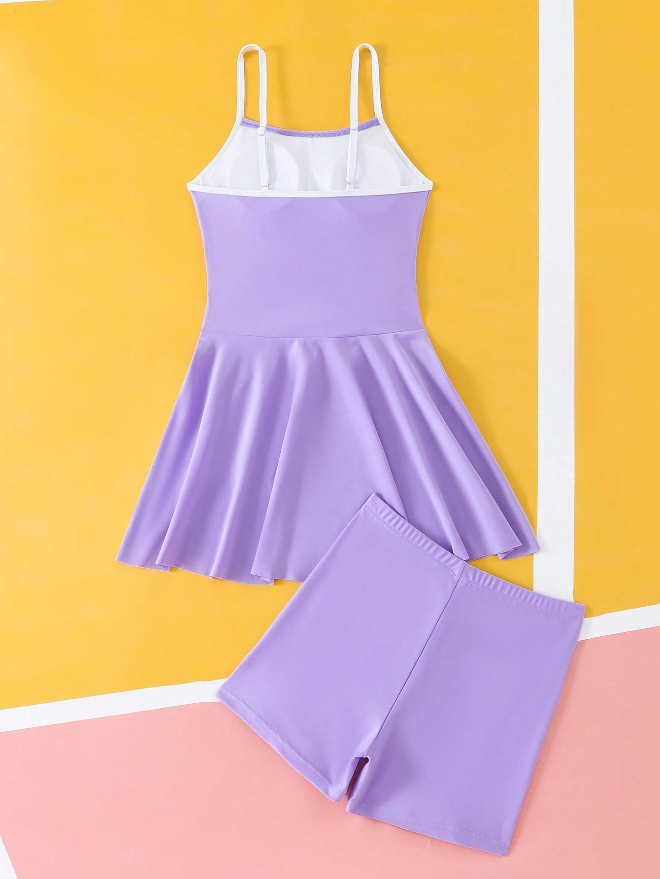 Tween girls black two-piece tankini swimwear set featuring a spaghetti strap sleeveless top with cutout detail and contrast piping, paired with short swim shorts.