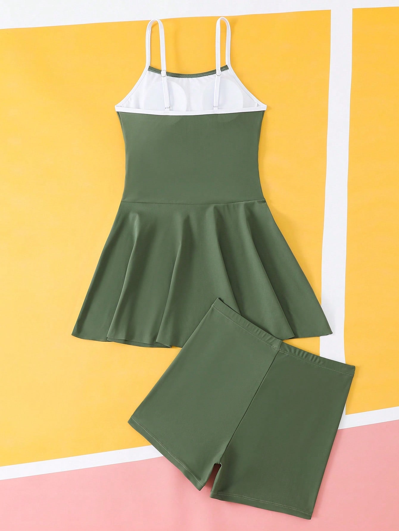 Tween girls black two-piece tankini swimwear set featuring a spaghetti strap sleeveless top with cutout detail and contrast piping, paired with short swim shorts.