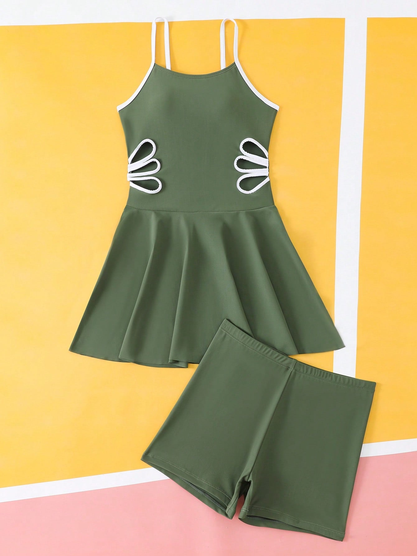 Tween girls black two-piece tankini swimwear set featuring a spaghetti strap sleeveless top with cutout detail and contrast piping, paired with short swim shorts.