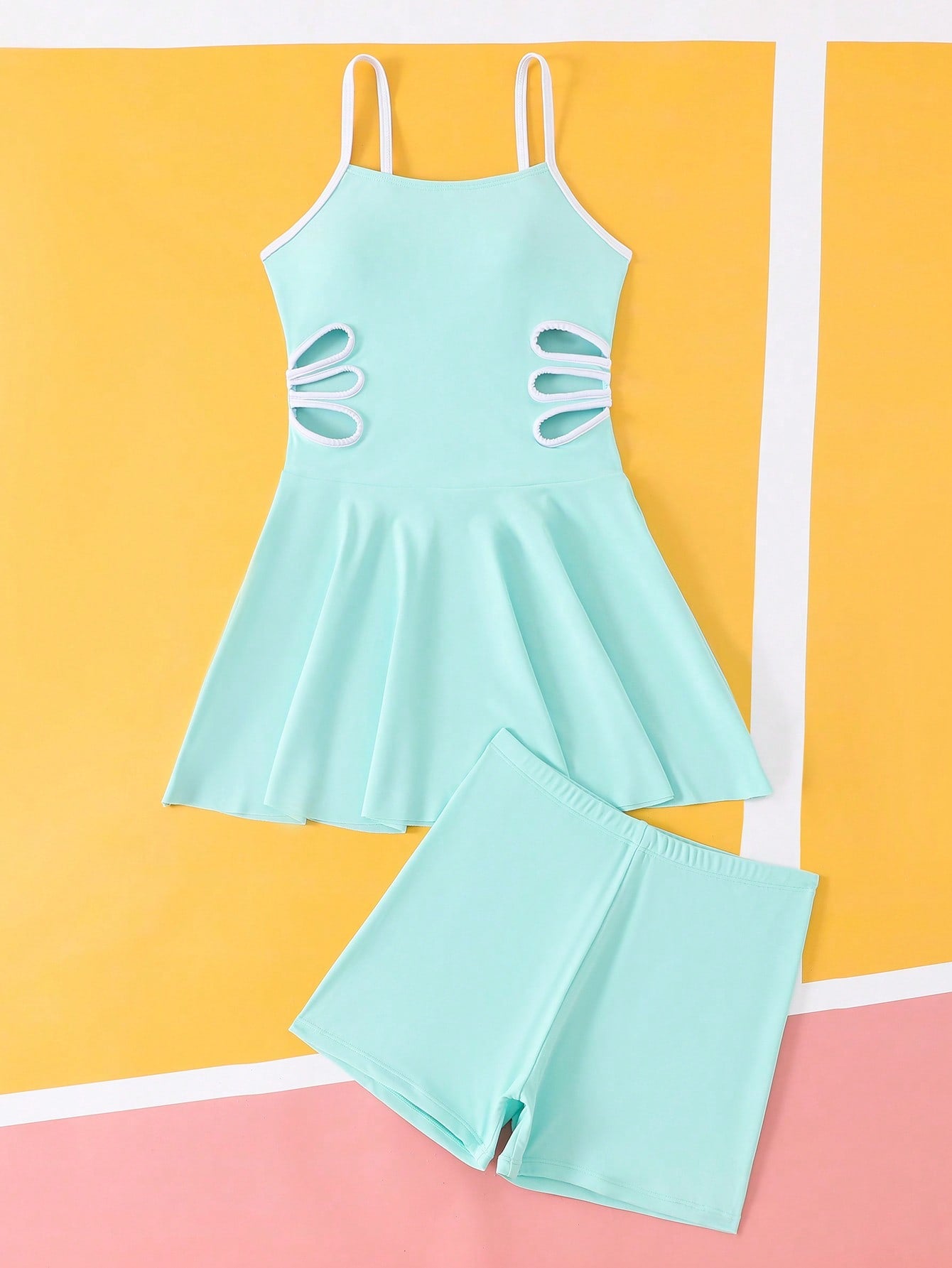 Tween girls black two-piece tankini swimwear set featuring a spaghetti strap sleeveless top with cutout detail and contrast piping, paired with short swim shorts.
