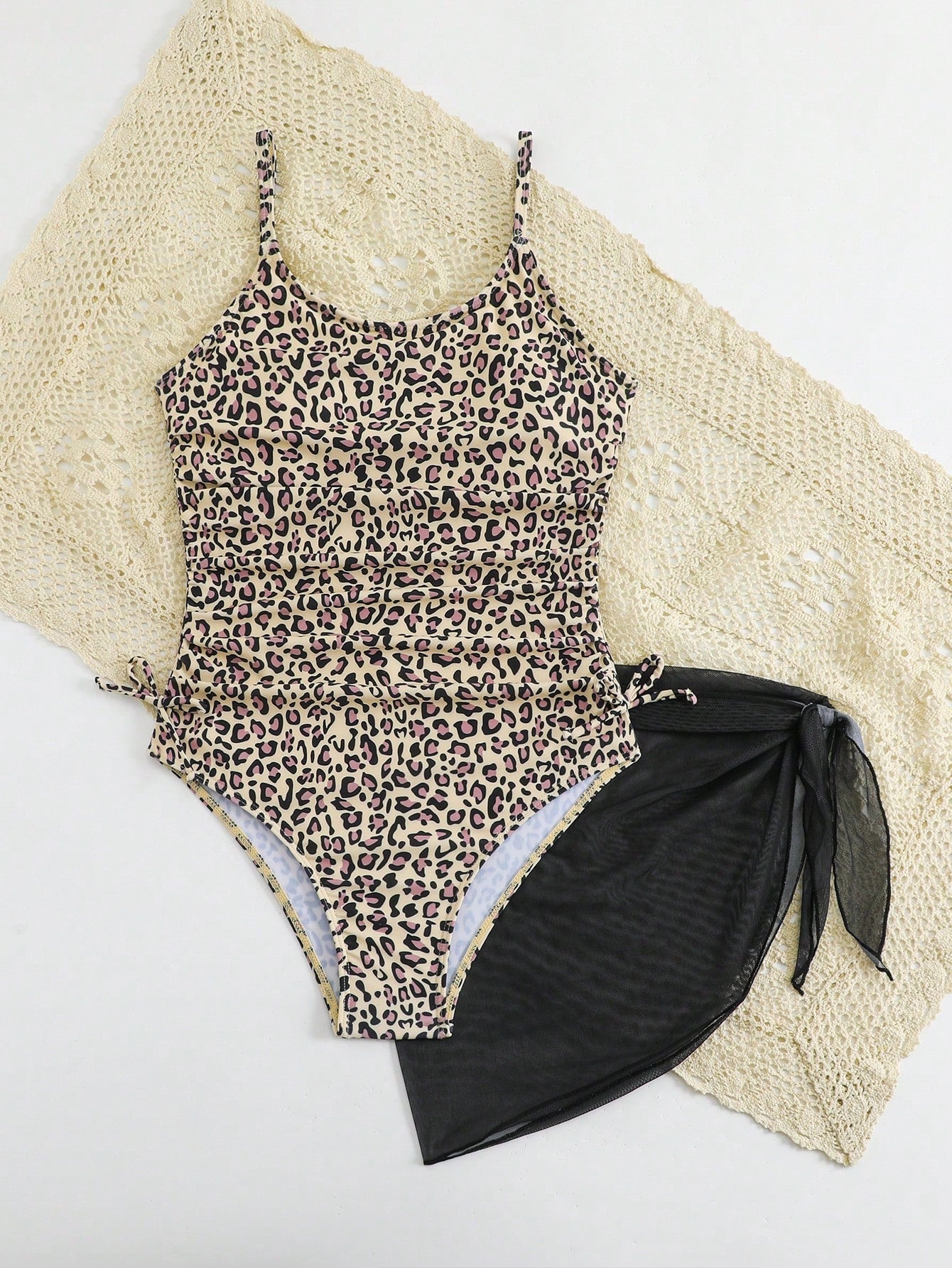 Tween girls 2-piece swimsuit in black with pink floral print, featuring spaghetti straps, bow decor, mesh detail, and a skirted mid-waist bottom. Sleeveless vacation-style swim set with medium-stretch fabric.