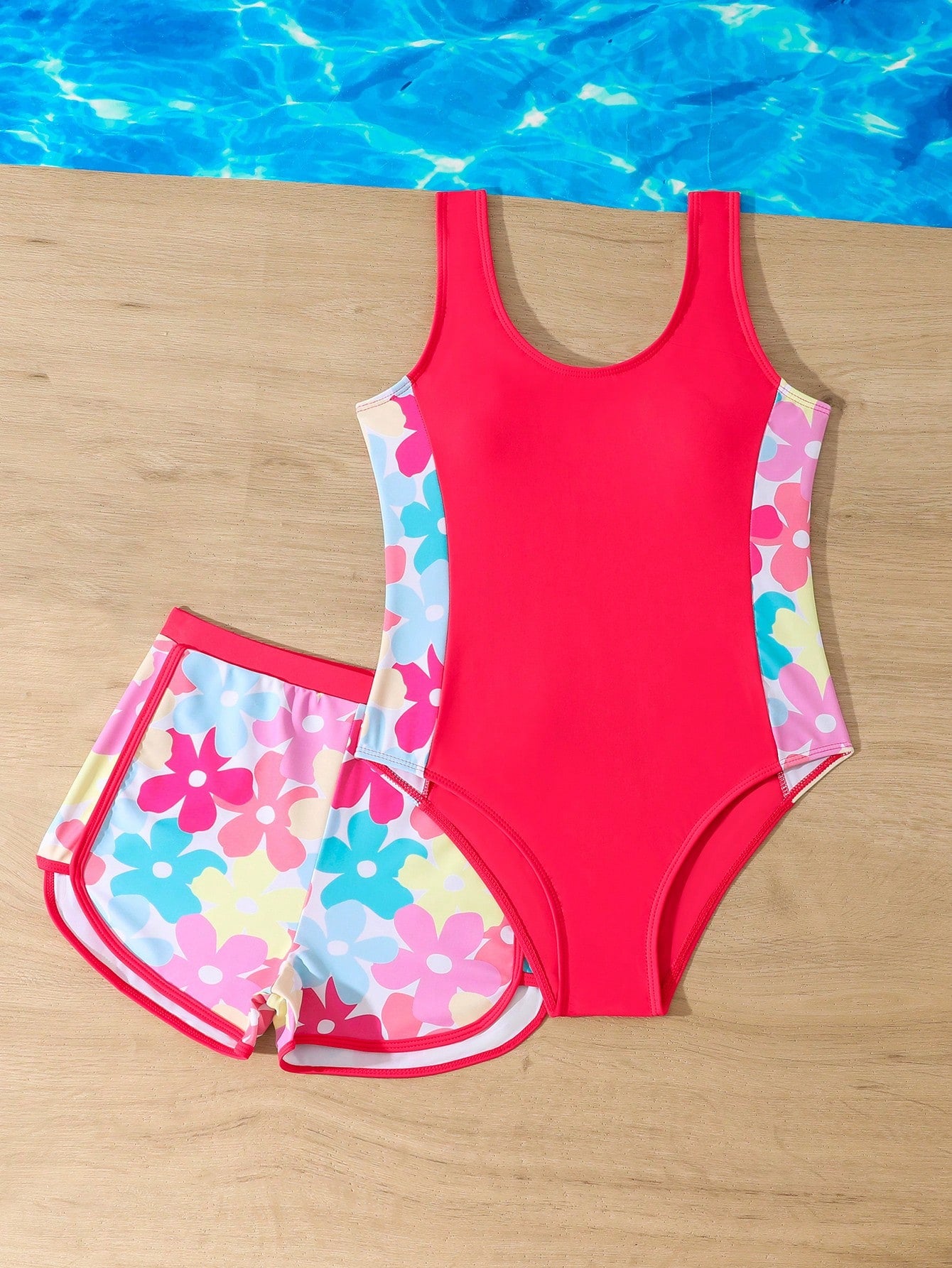 Tween girls 2-piece swimsuit set in black with full floral and plant print, featuring a sleeveless scoop-neck swim top and matching shorts-style bottoms.