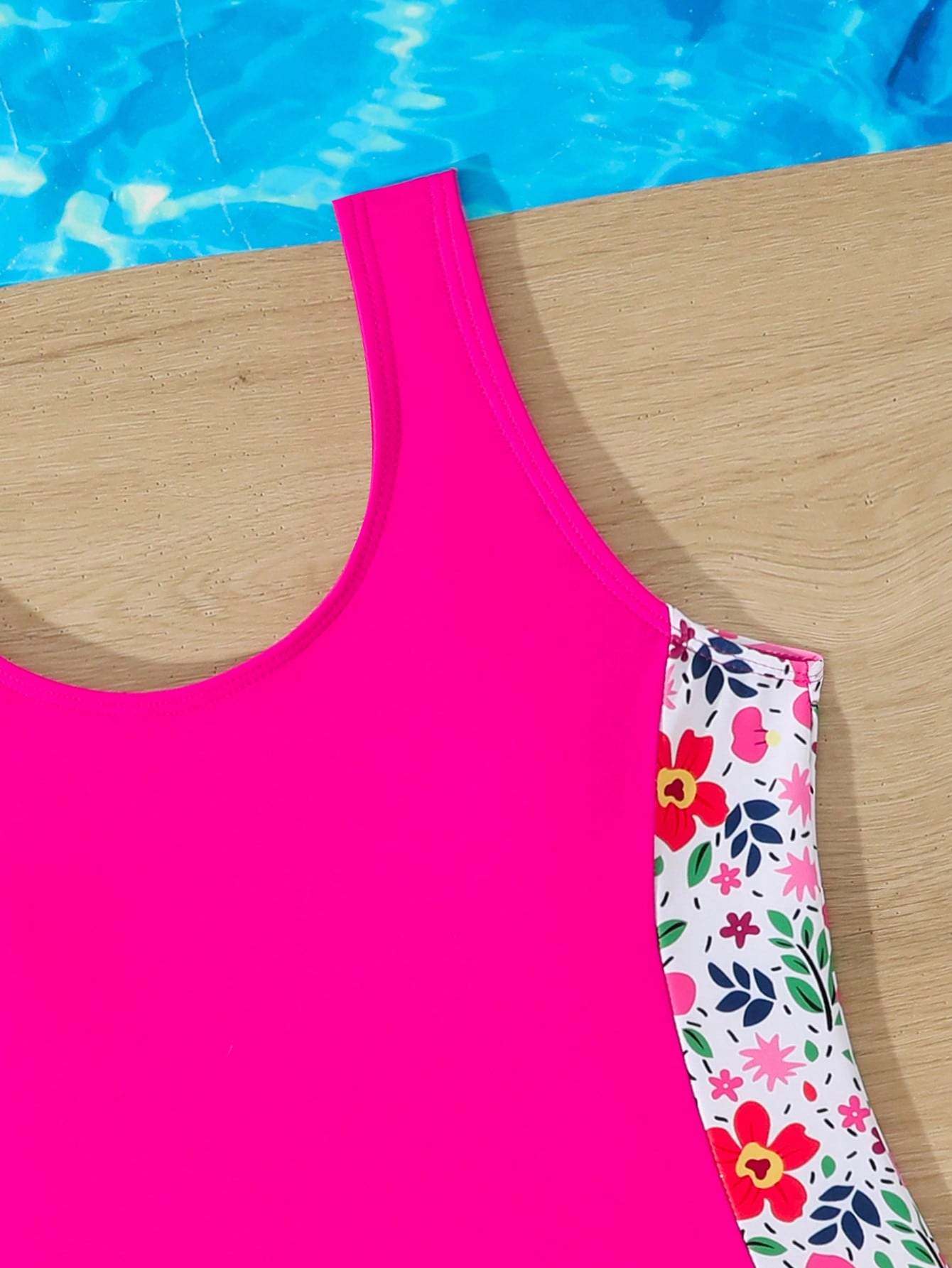 Tween girls 2-piece swimsuit set in black with full floral and plant print, featuring a sleeveless scoop-neck swim top and matching shorts-style bottoms.