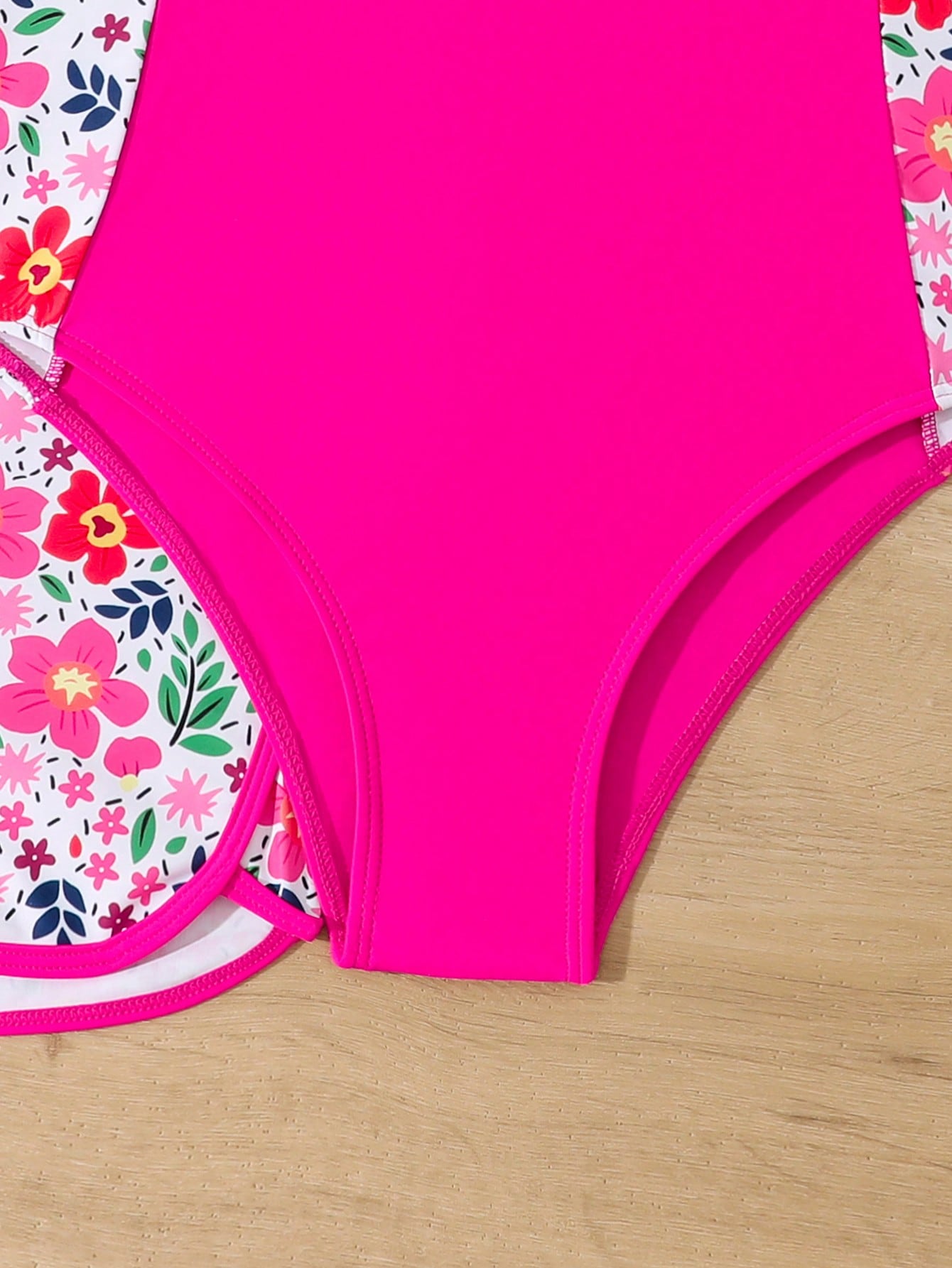 Tween girls 2-piece swimsuit set in black with full floral and plant print, featuring a sleeveless scoop-neck swim top and matching shorts-style bottoms.