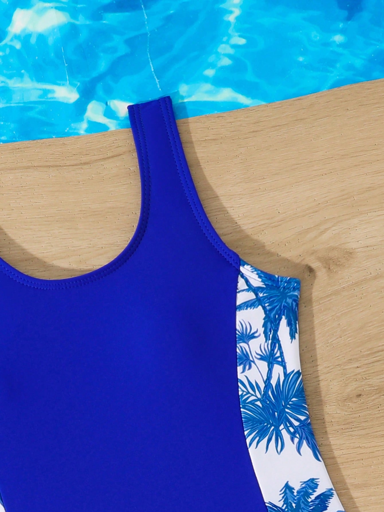 Tween girls 2-piece swimsuit set in black with full floral and plant print, featuring a sleeveless scoop-neck swim top and matching shorts-style bottoms.